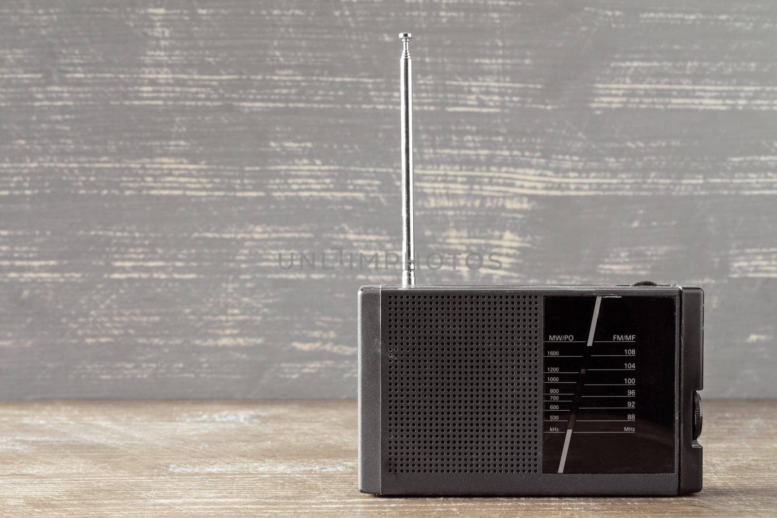 Old portable radio receiver device on wooden background
