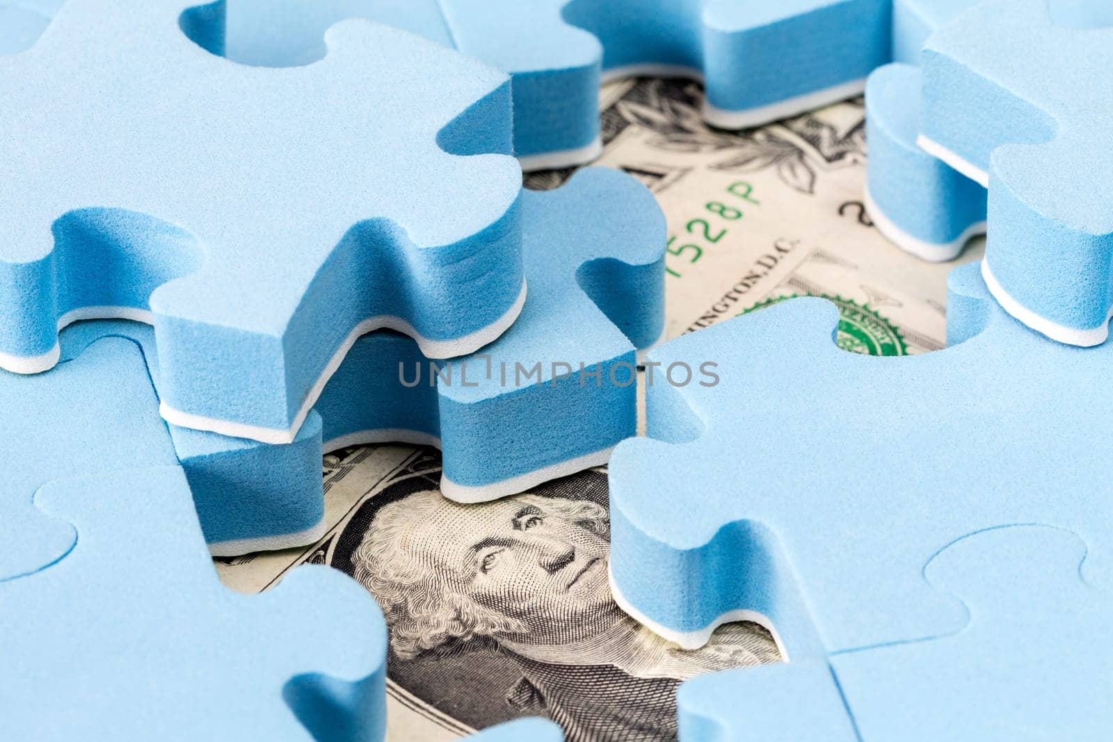 US dollar banknote hidden under puzzle, financial concept