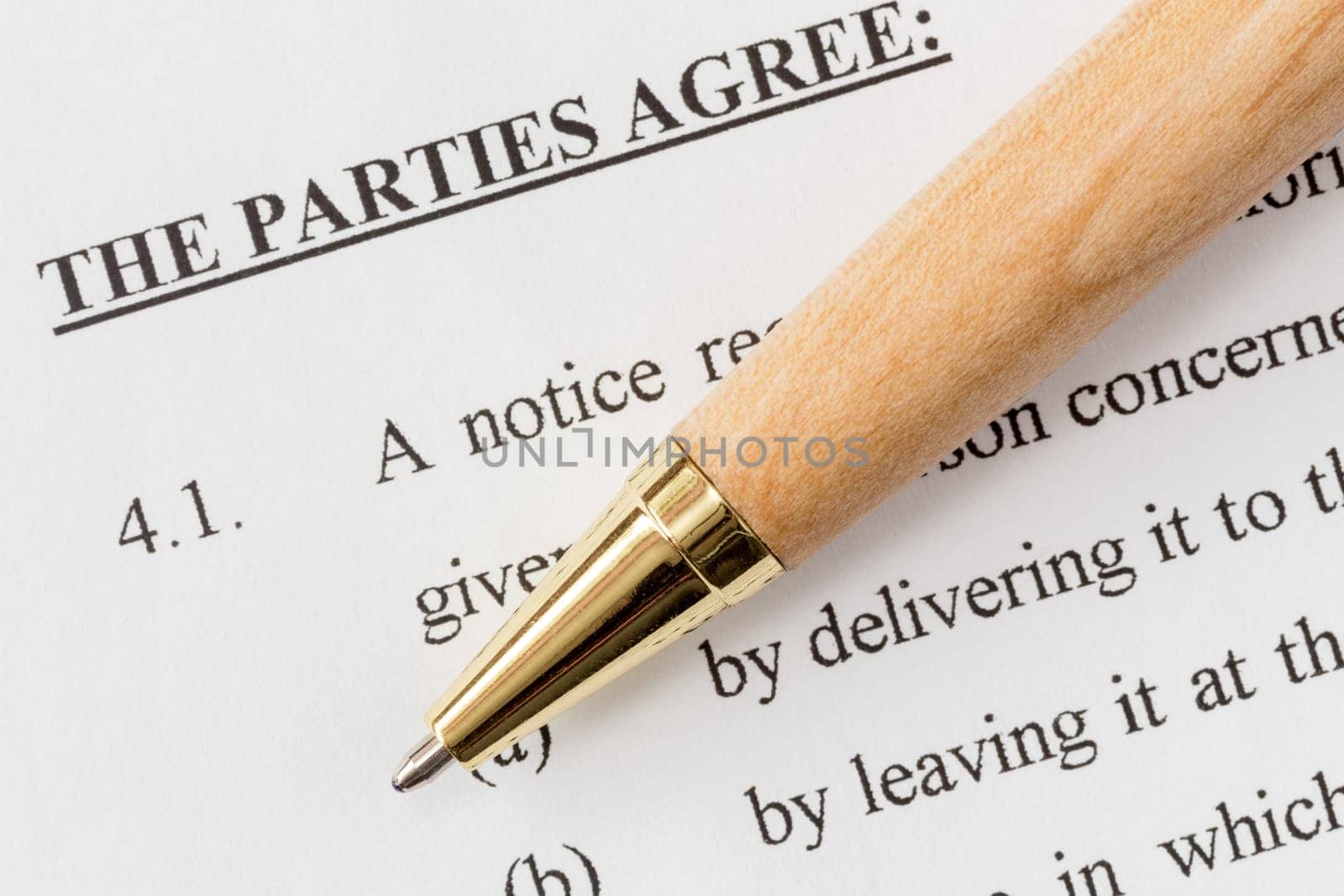 Wooden pen over a printed agreement