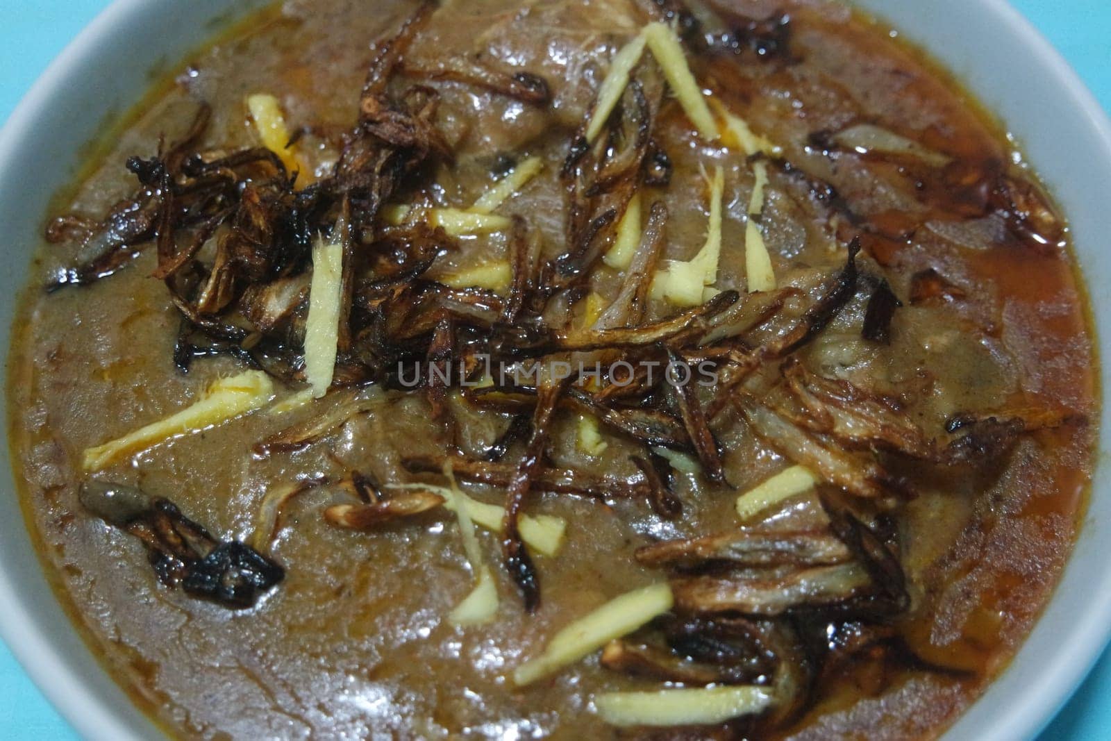 Closeup view of traditional Pakistani Haleem dish with salad and Lemon juice.