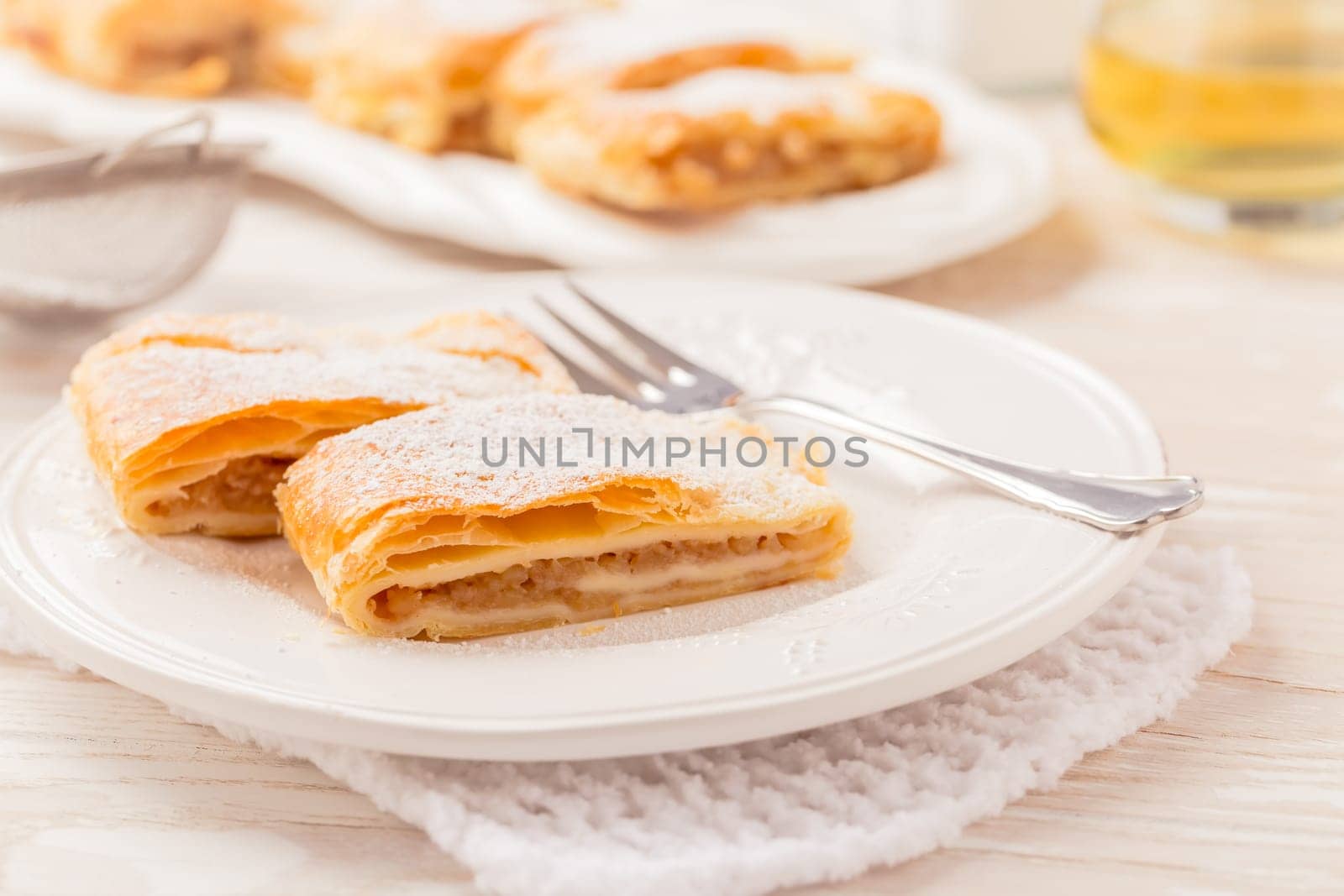 Homemade apple strudel (apfelstrudel) on white plate. Popular pastry cake in Europe