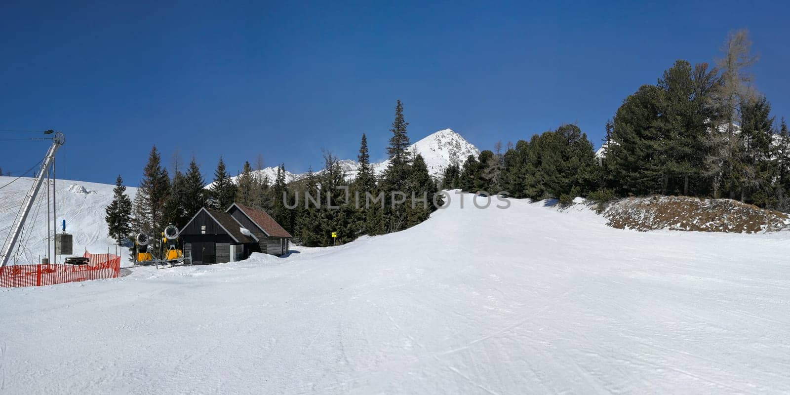 Empty red piste on Strbske pleso, Solisko ski resort, shot on Easter skiing, sunny spring day with no clouds in deep blue sky. Vysoke Tatry, Slovakia