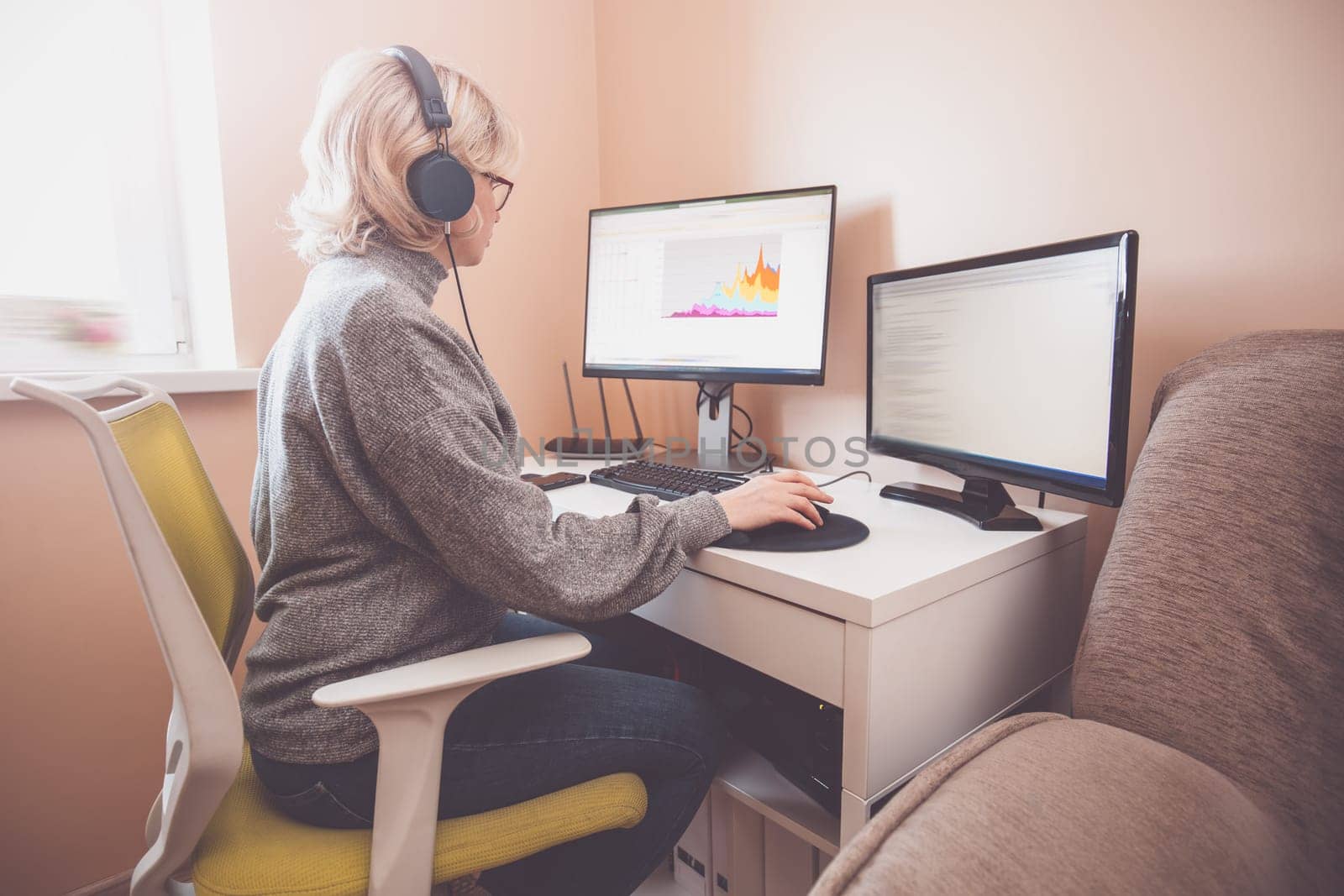 woman working at home in homeoffice. Young businesswoman sitting indoors and using pc