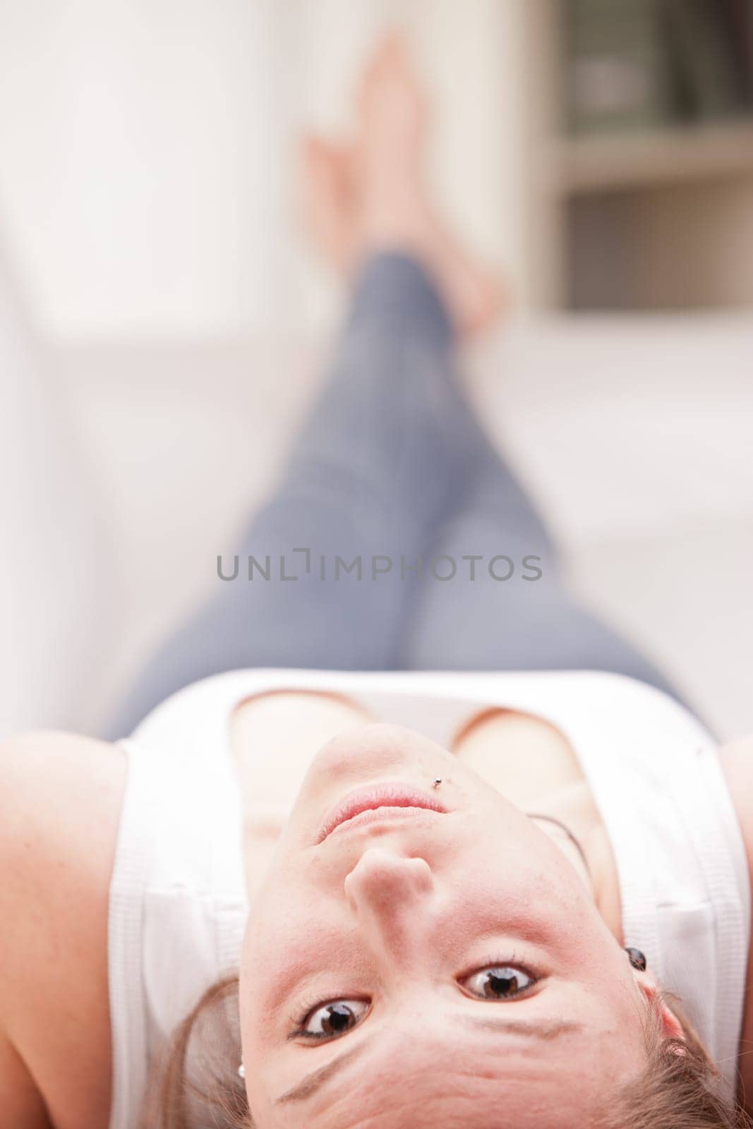 young happy brunette lying on a couch in her living room