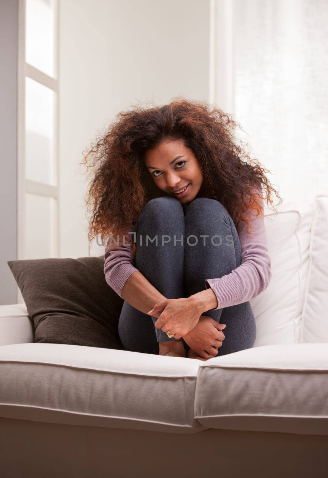 curly beautiful african-american woman lying on a sofa