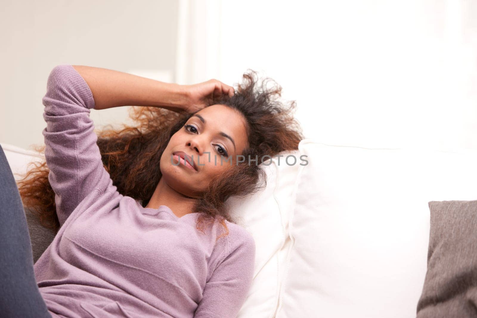 curly beautiful african-american woman lying on a sofa