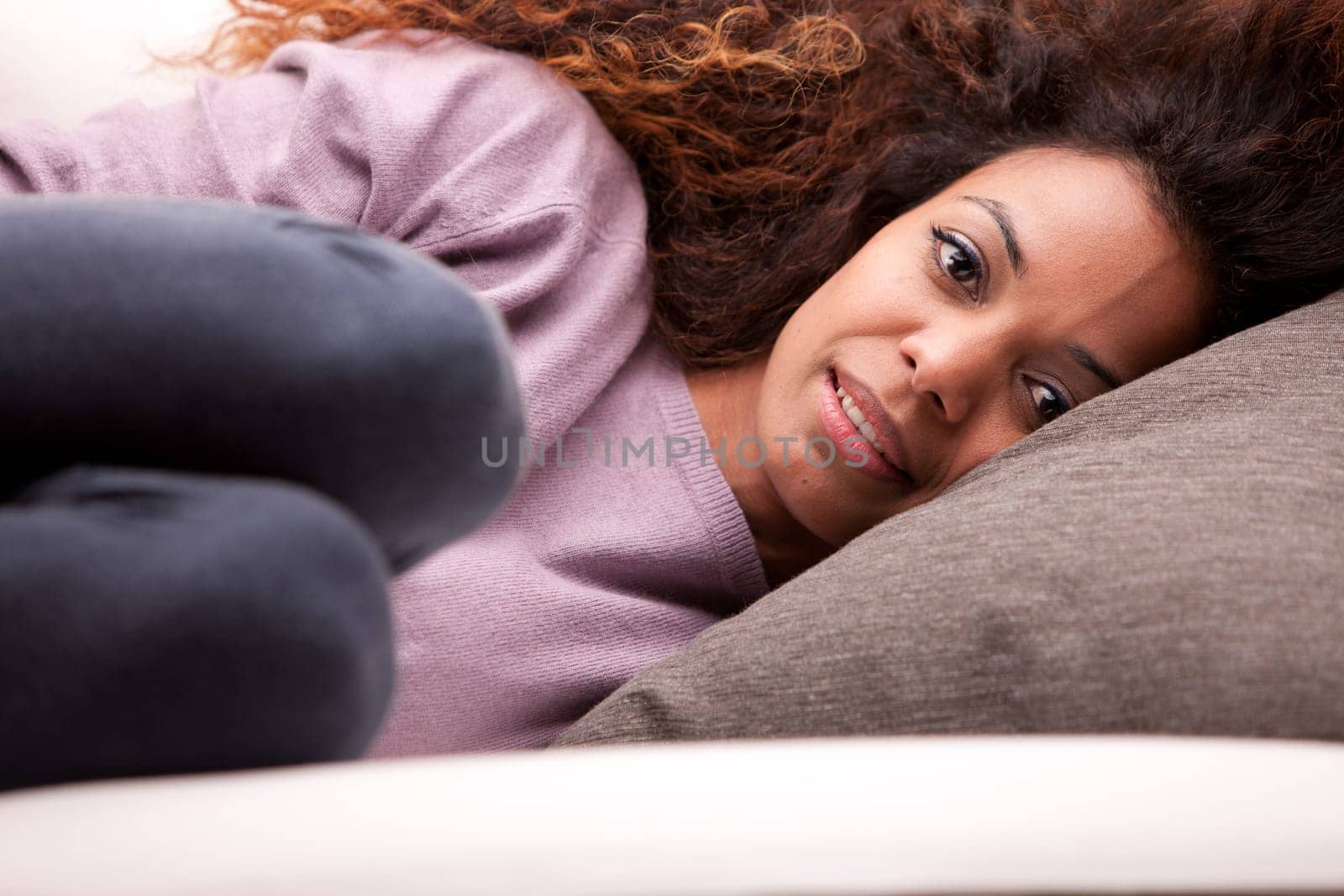 curly beautiful african-american woman lying on a sofa