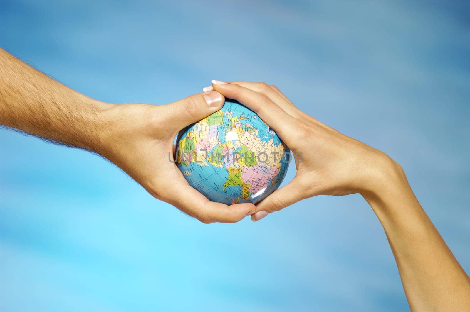 Close-up of a man and a womanŽs hands holding a globe
