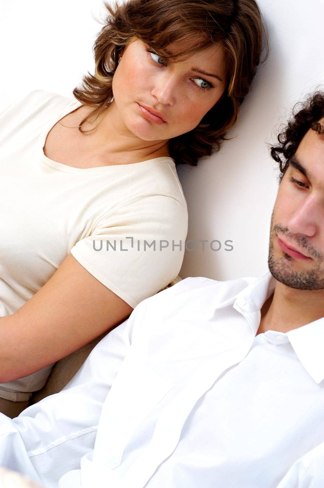 Close-up of a young couple sitting against a wall
