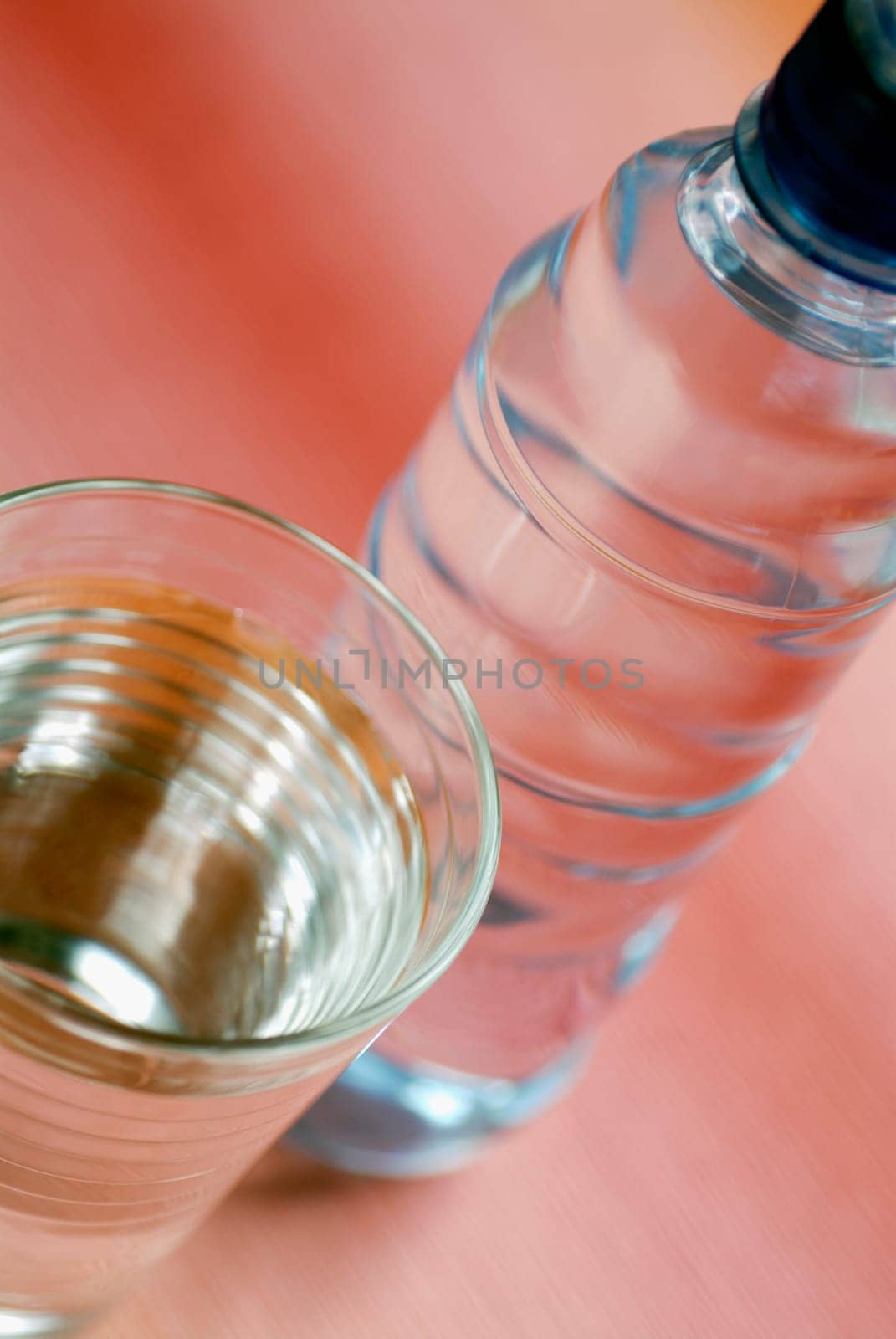 Close-up of a glass of water with a water bottle