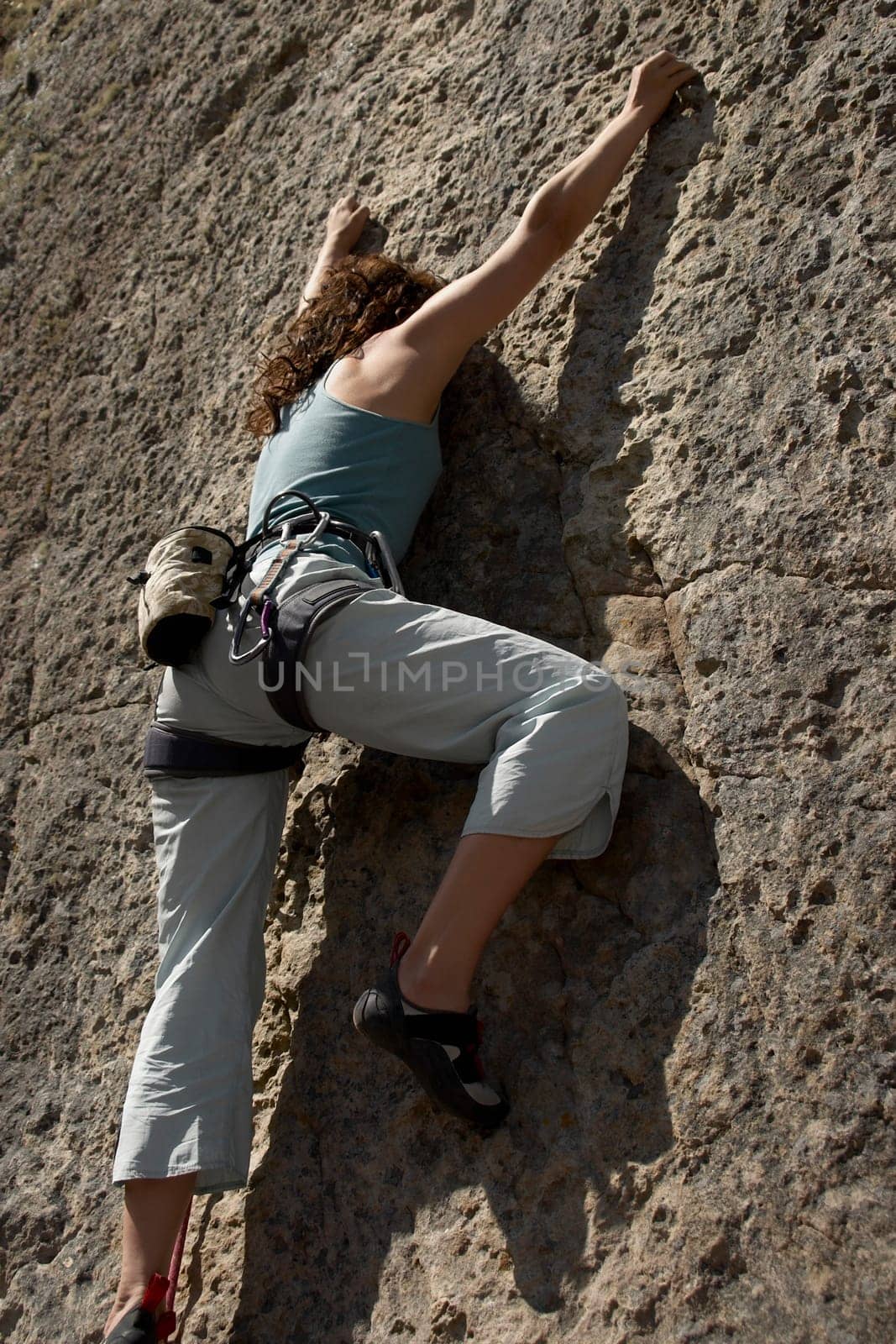 Female rock climber scaling a rock face
