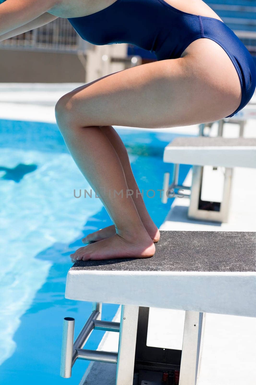 Side profile of a young woman taking start from a diving platform