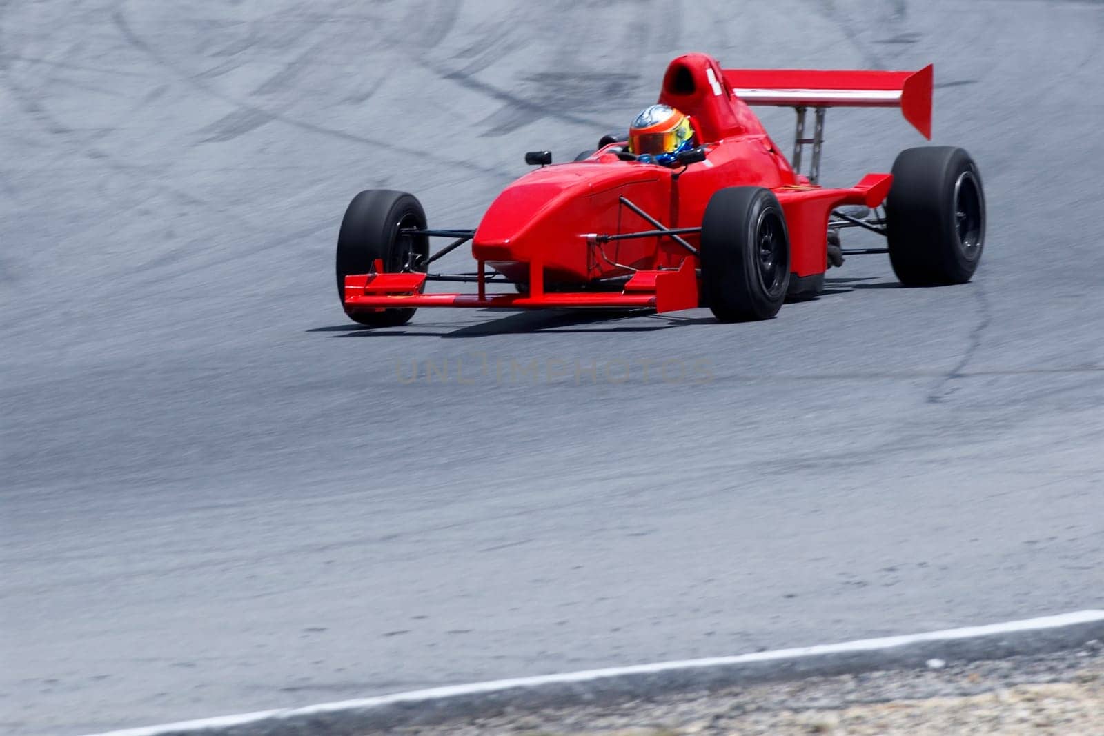 Person driving a formula one racing car on a motor racing track