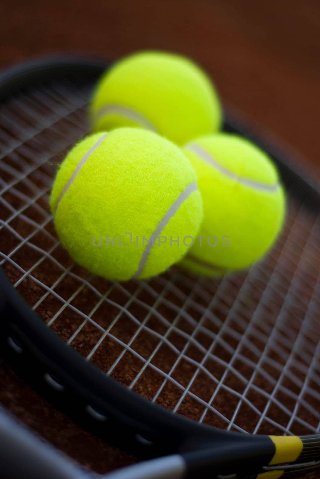 Close-up of three tennis balls on a tennis racket