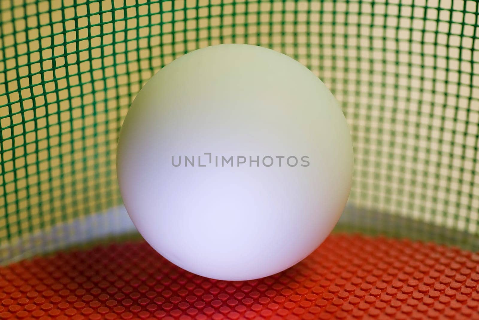 Close-up of a table tennis ball on a red table tennis racket