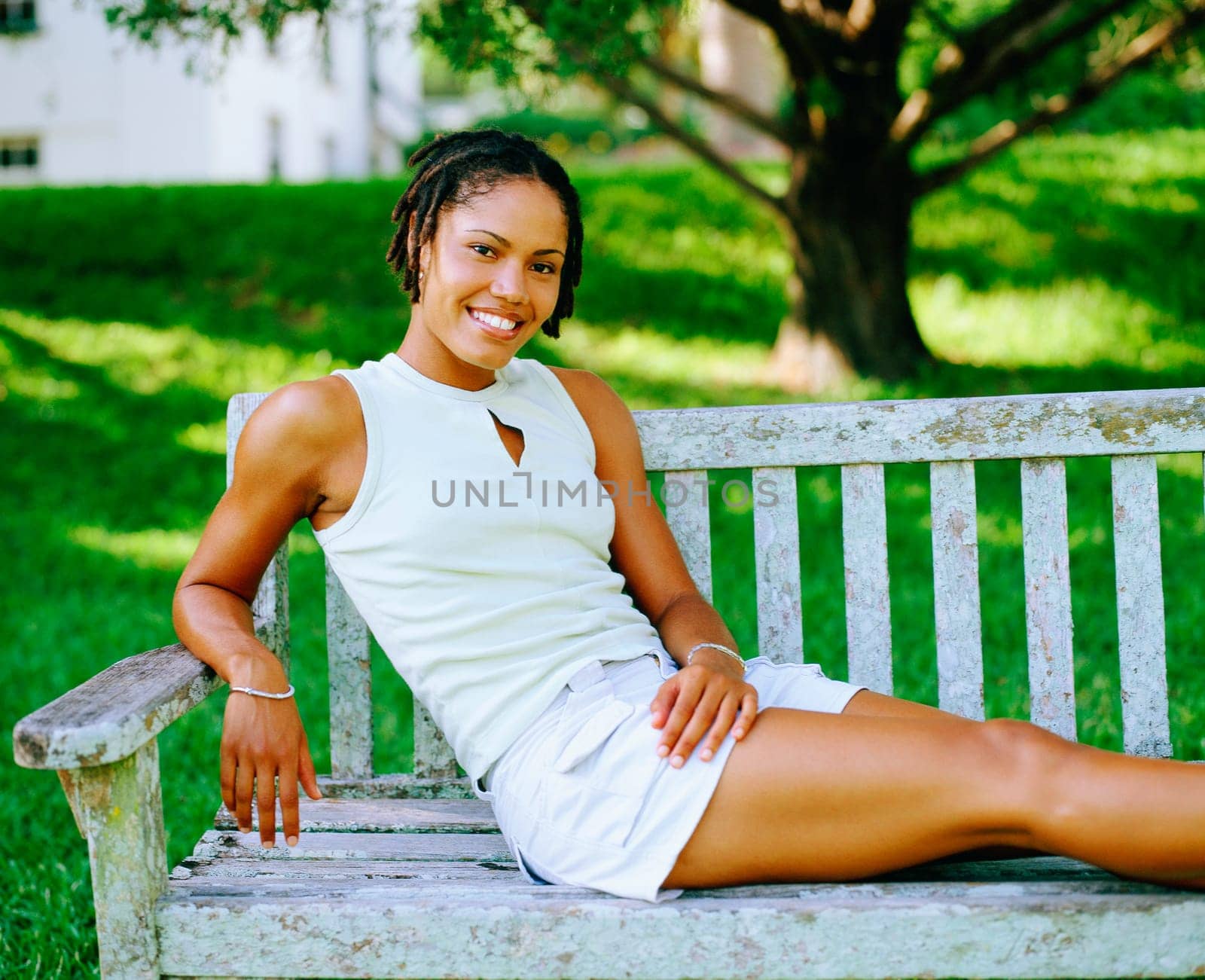 Portrait of a young woman sitting on a bench and smiling, Bermuda