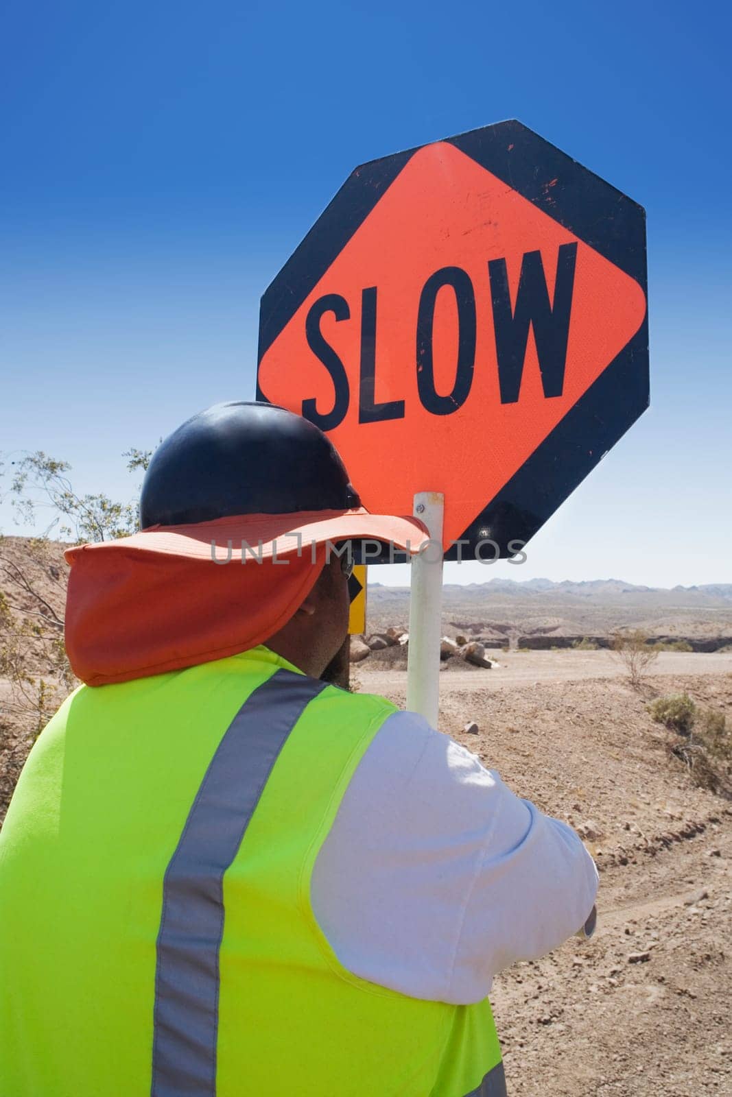 Rear view of a man standing with a road sign