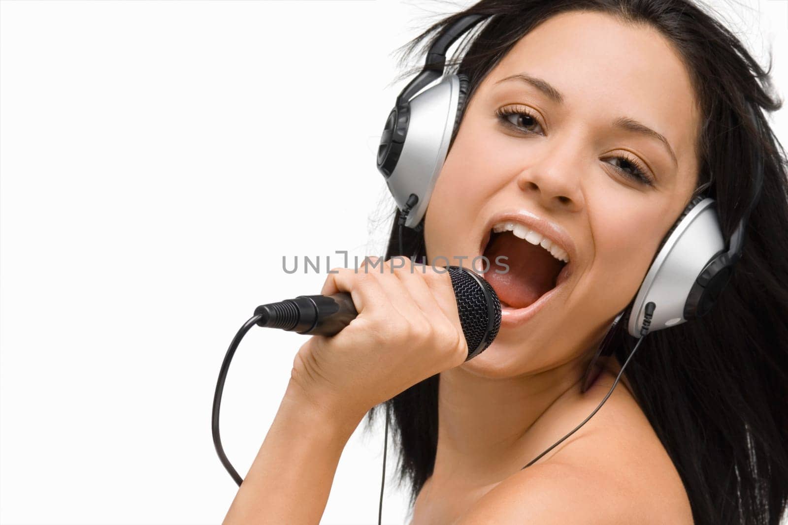 Portrait of a young woman singing into a microphone