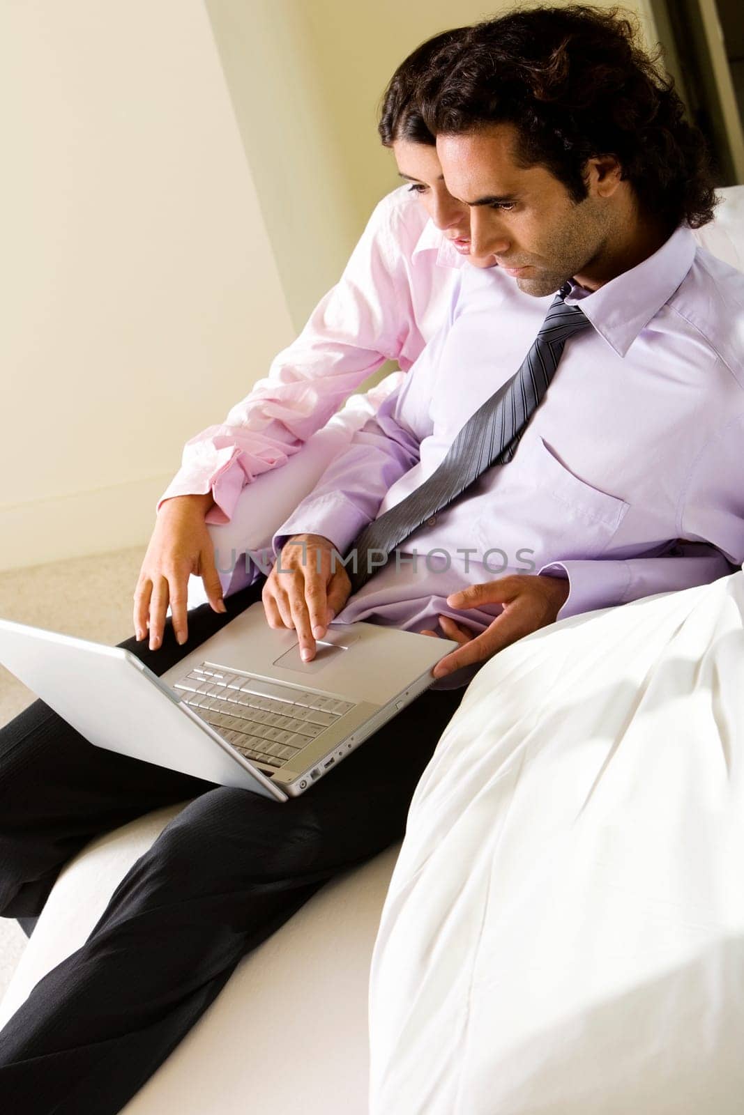 Side profile of a businessman and a businesswoman in front of a laptop