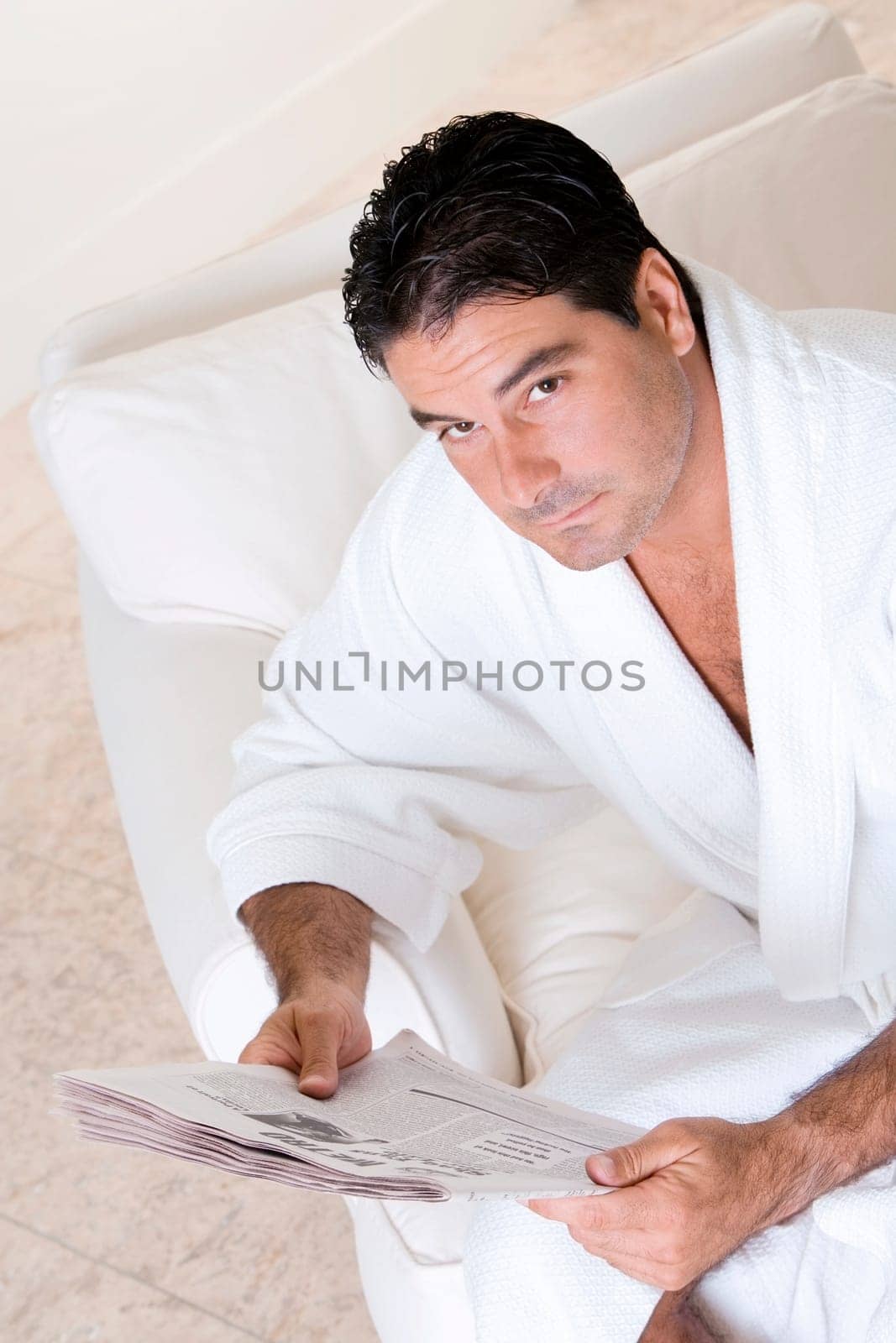 High angle view of a mid adult man holding a newspaper