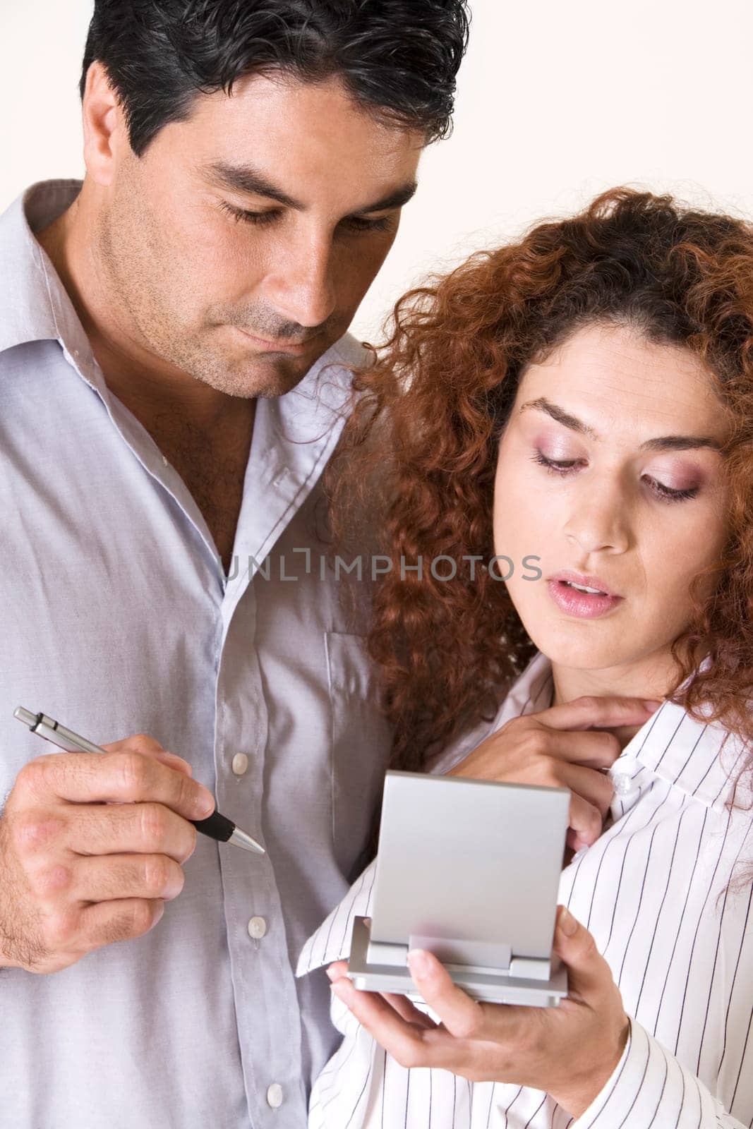 Close-up of a young woman and a mid adult man using a calculator
