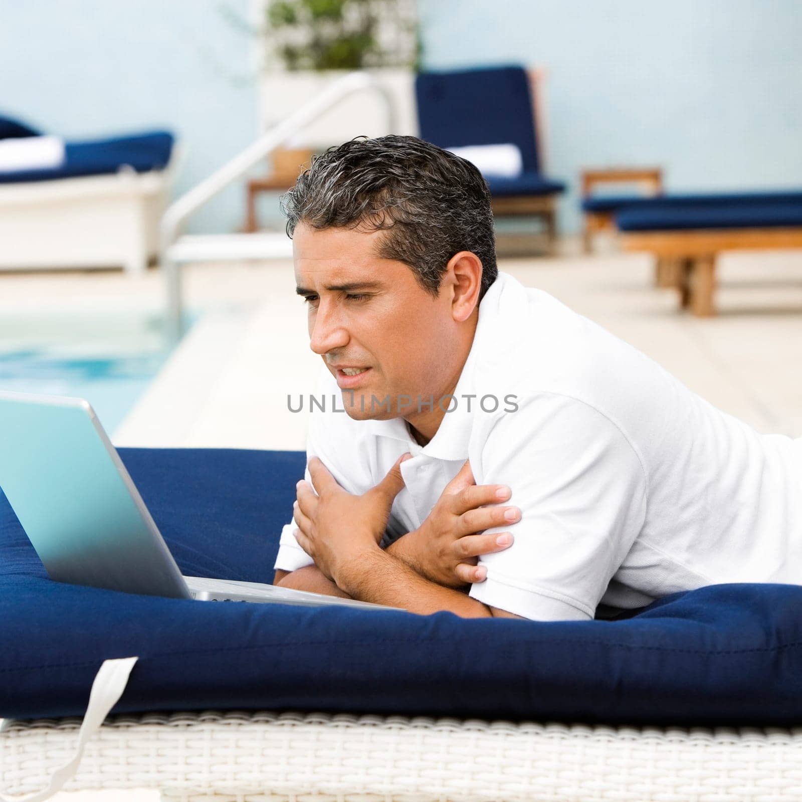 Side profile of a mid adult man using a laptop