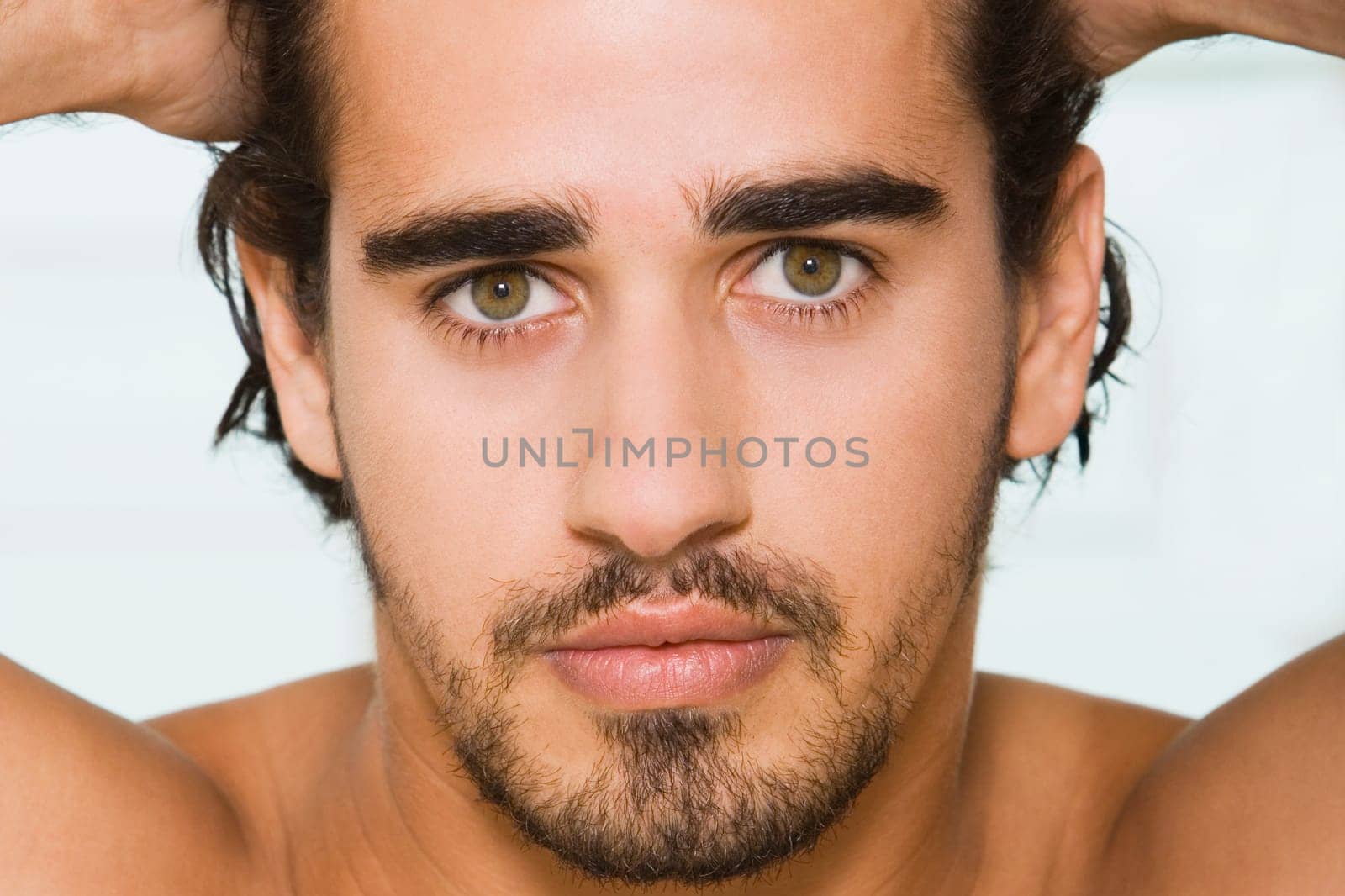Portrait of a young man with his hands on his head