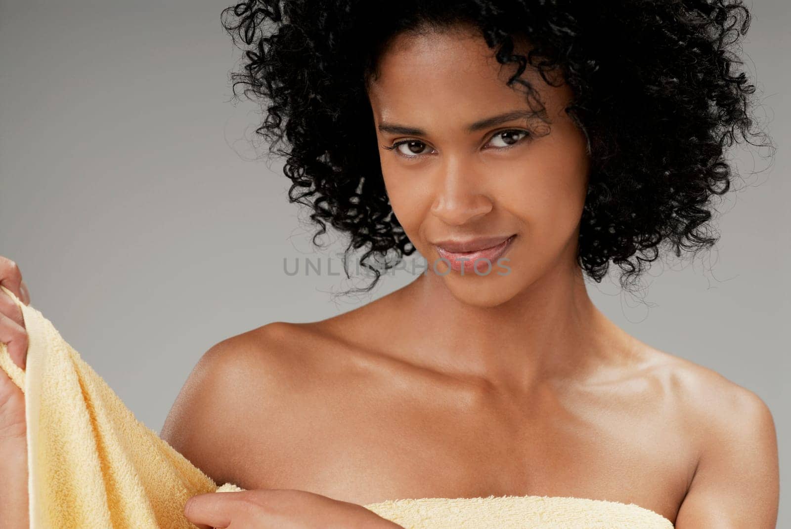 Portrait of a young woman adjusting a towel