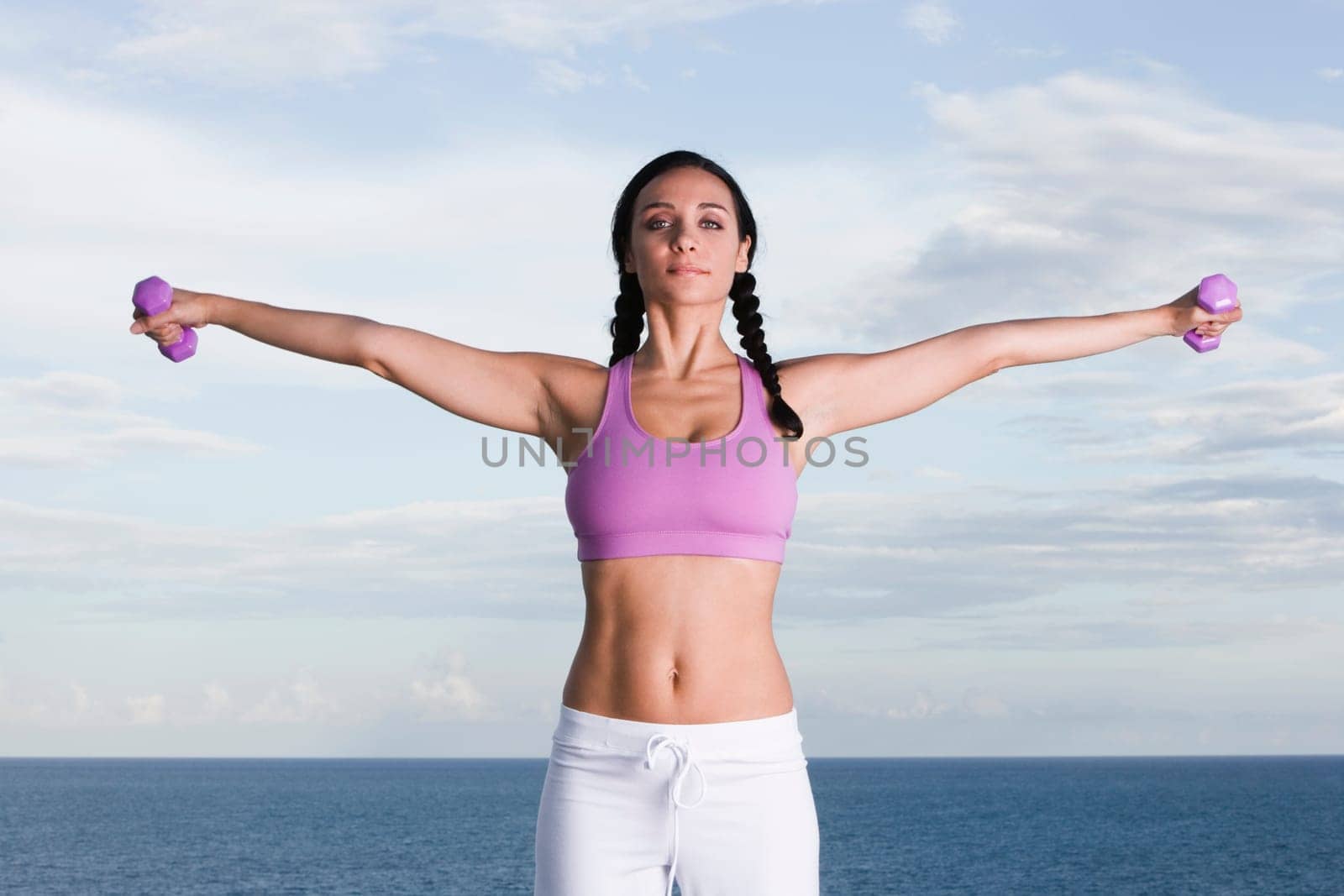 Portrait of a young woman exercising with dumbbells