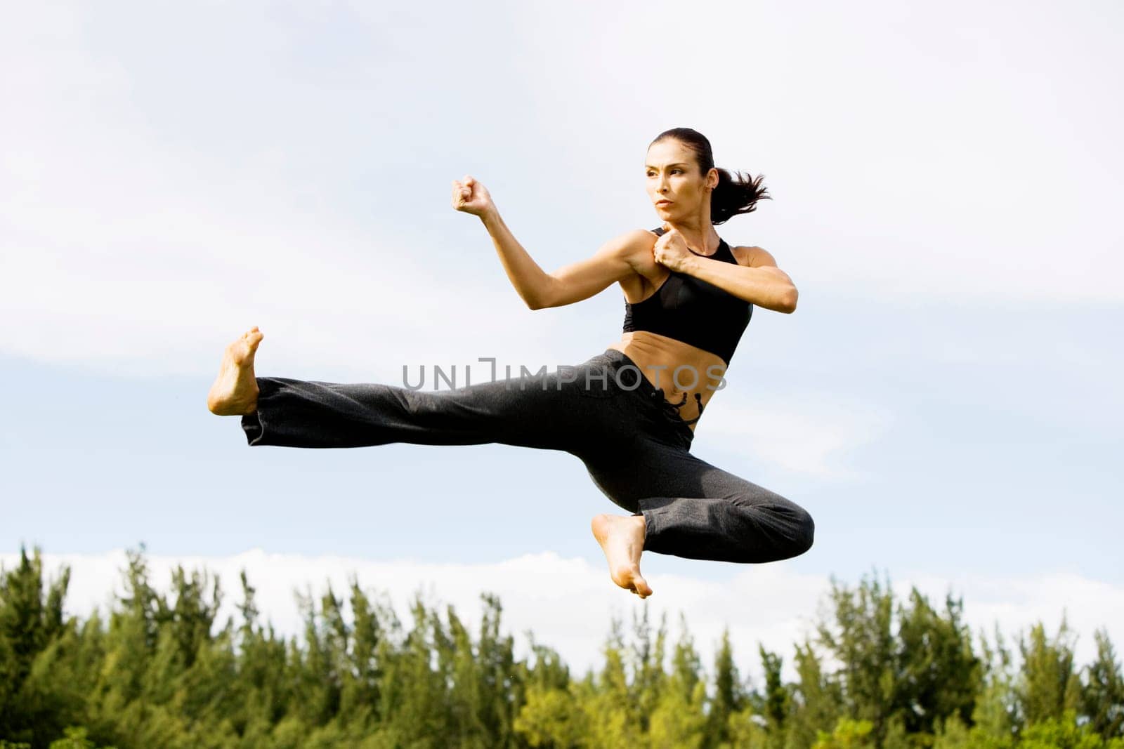 Low angle view of a young woman practicing martial arts