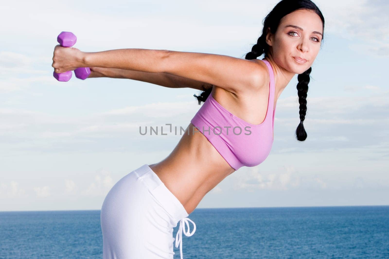 Portrait of a young woman exercising with dumbbells