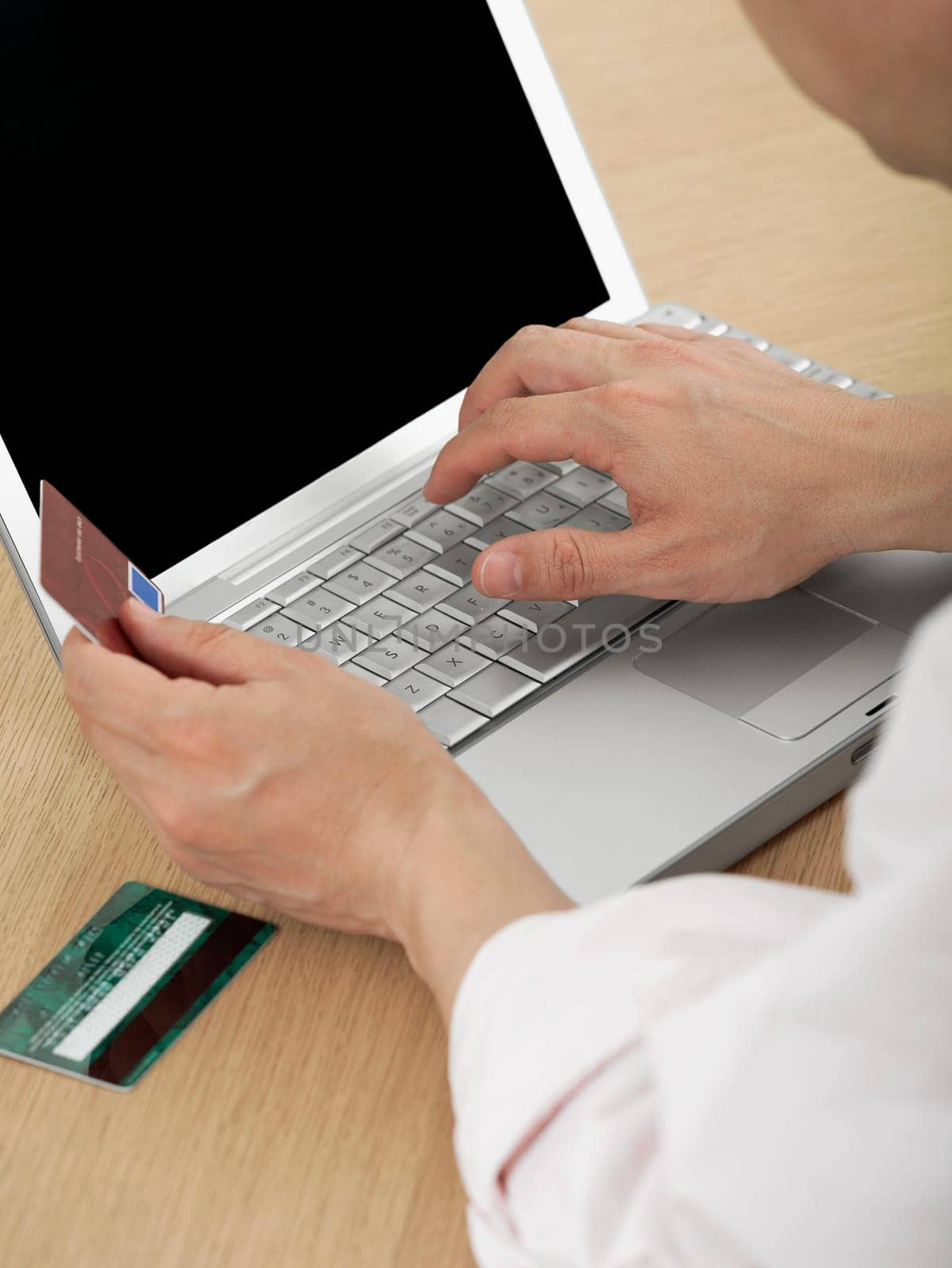 Close-up of a mature manŽs hand holding a credit card and using a laptop