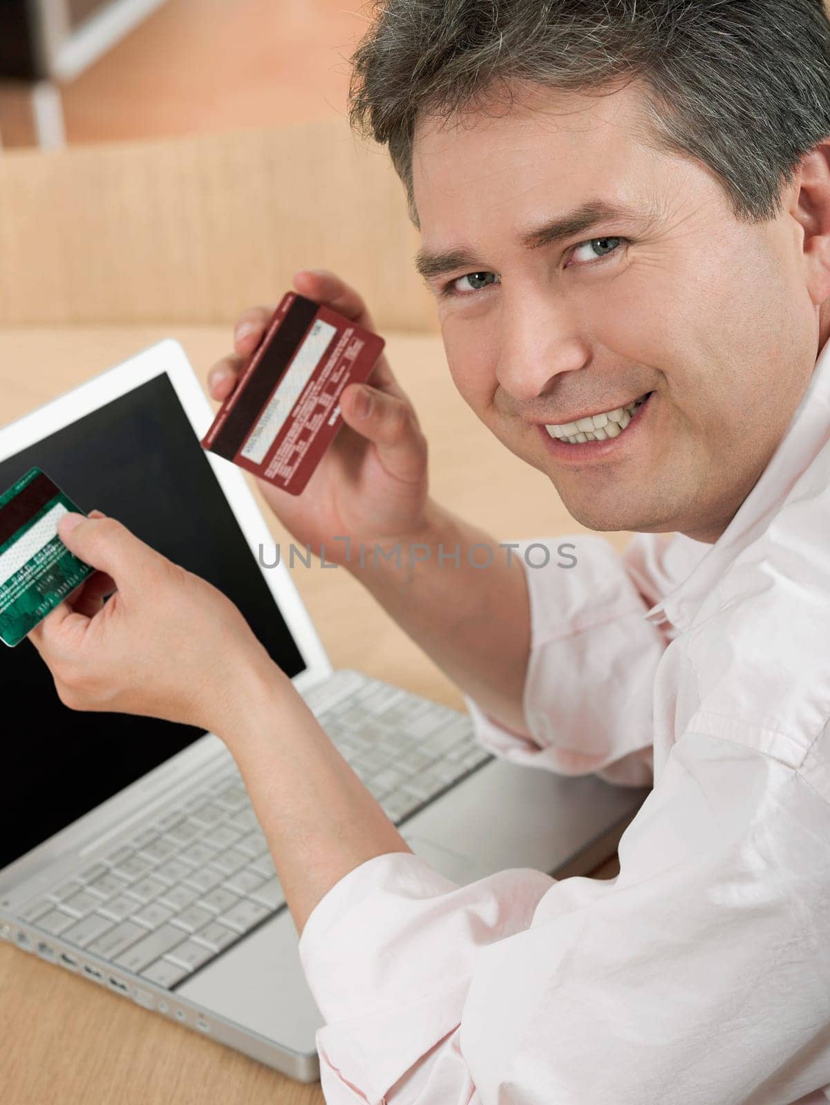 Portrait of a mature man holding two credit cards and smiling
