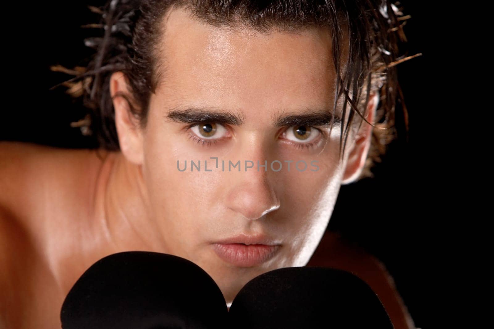 Portrait of a young man wearing boxing gloves