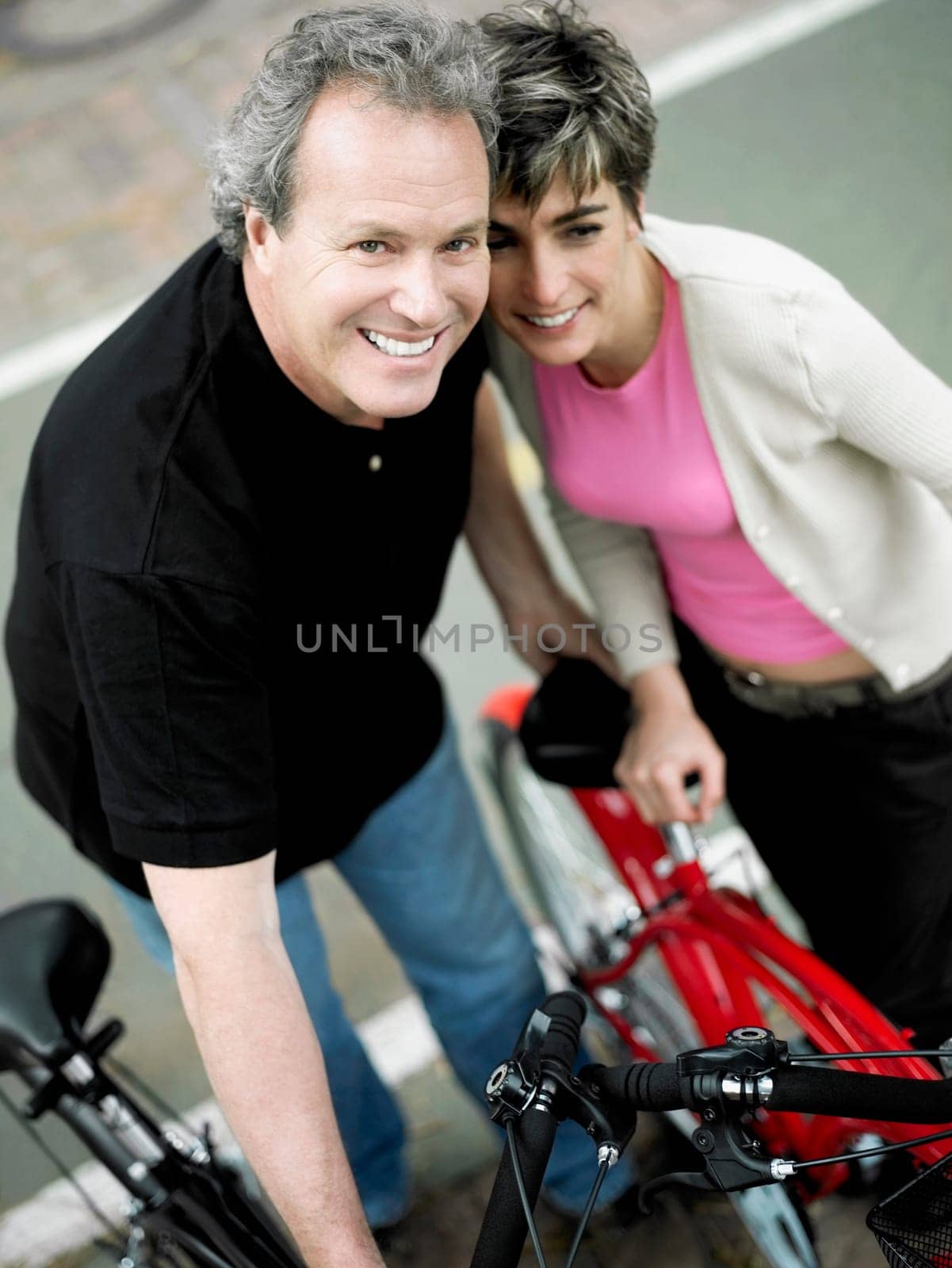 Portrait of a mature couple standing with bicycles and smiling