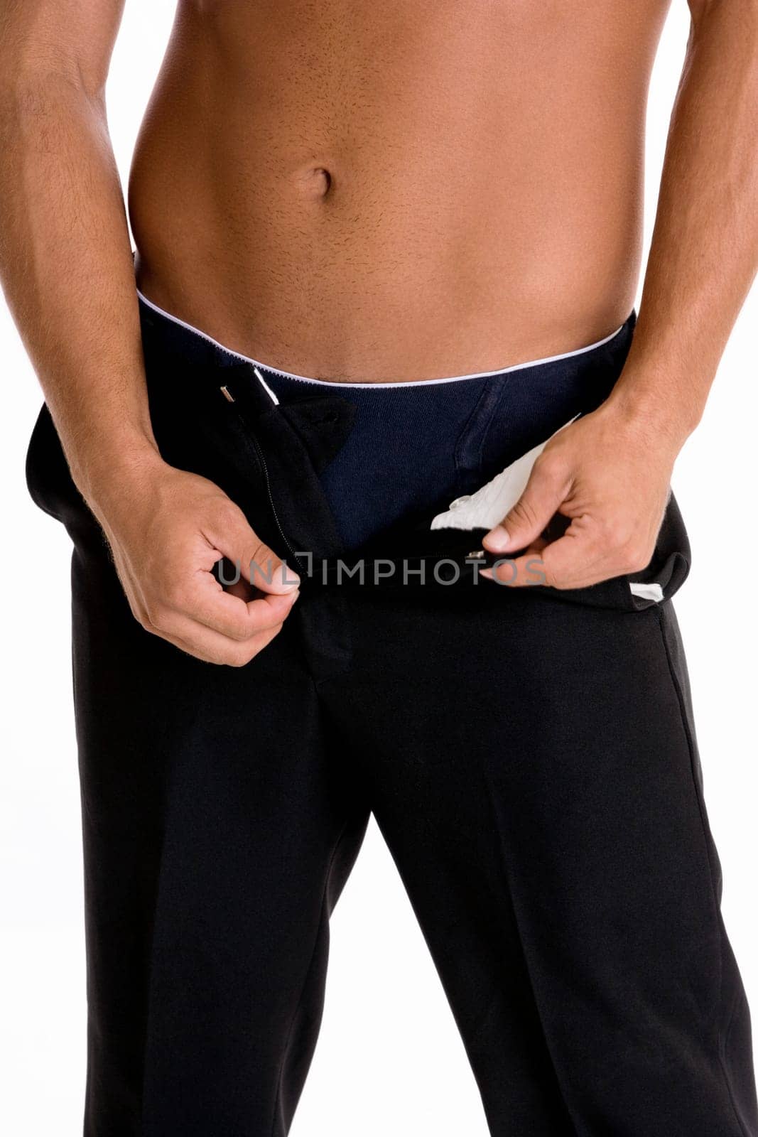 Mid section view of a man taking off his pants