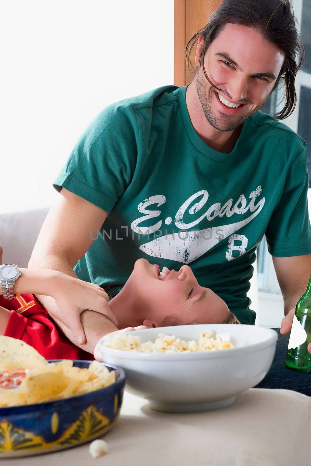 Young woman lying on the lap of a young man and smiling