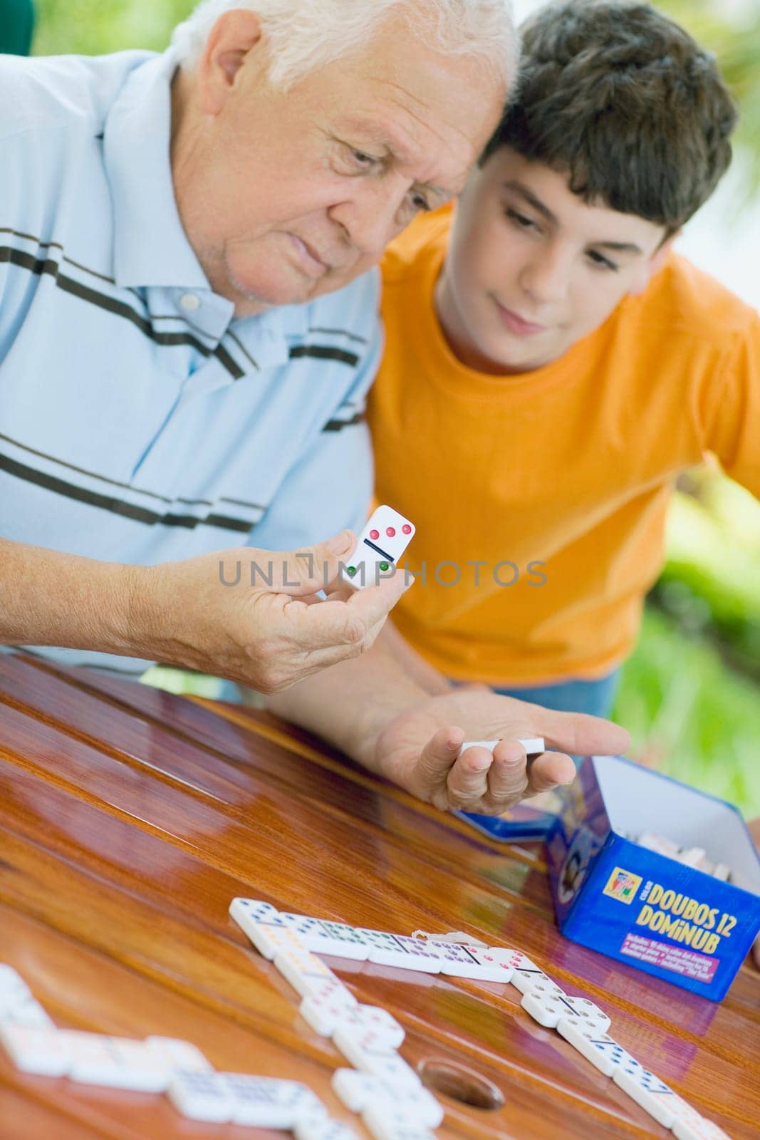 Senior man playing domino with his grandson