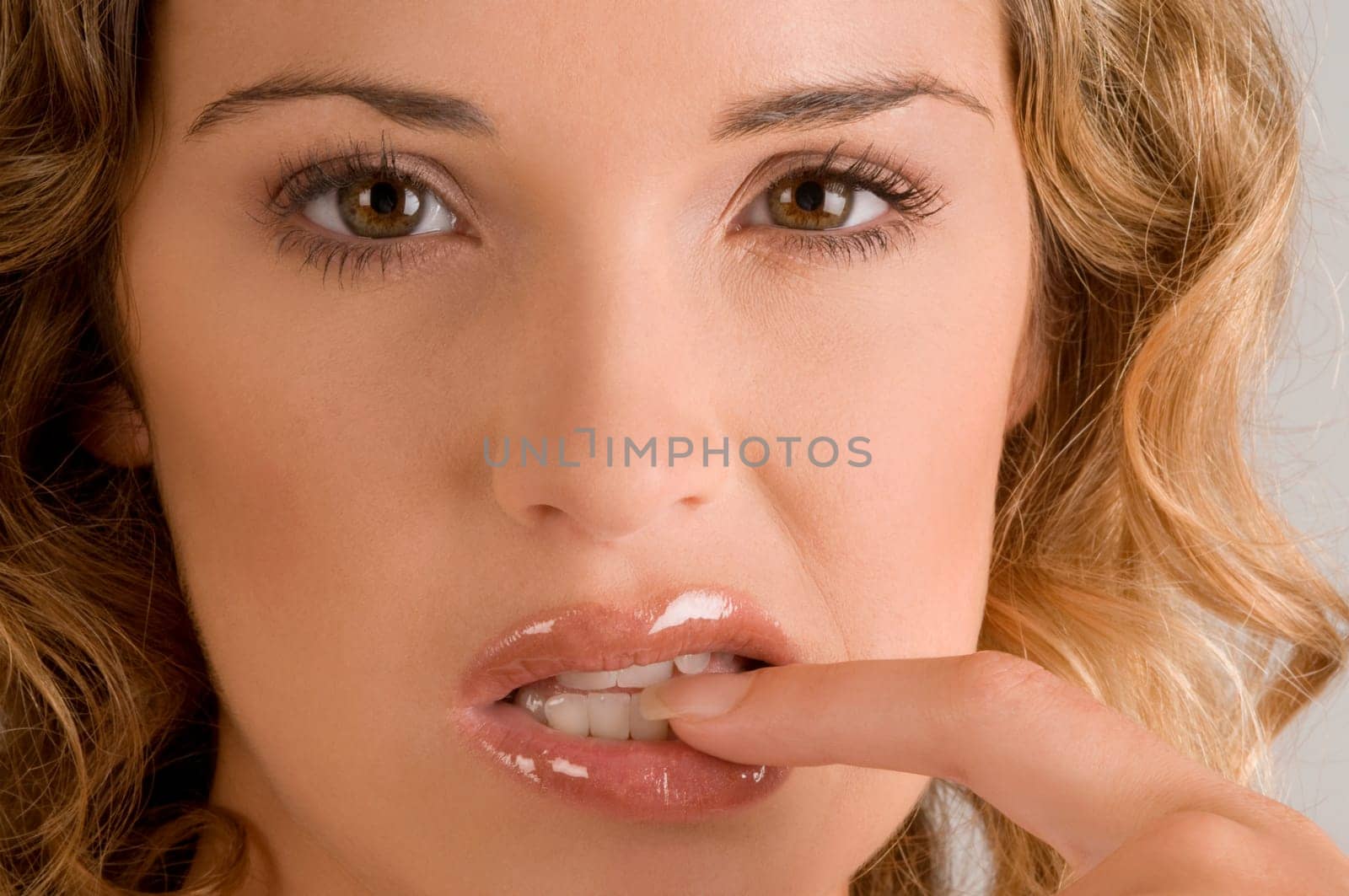 Portrait of a young woman biting her nail