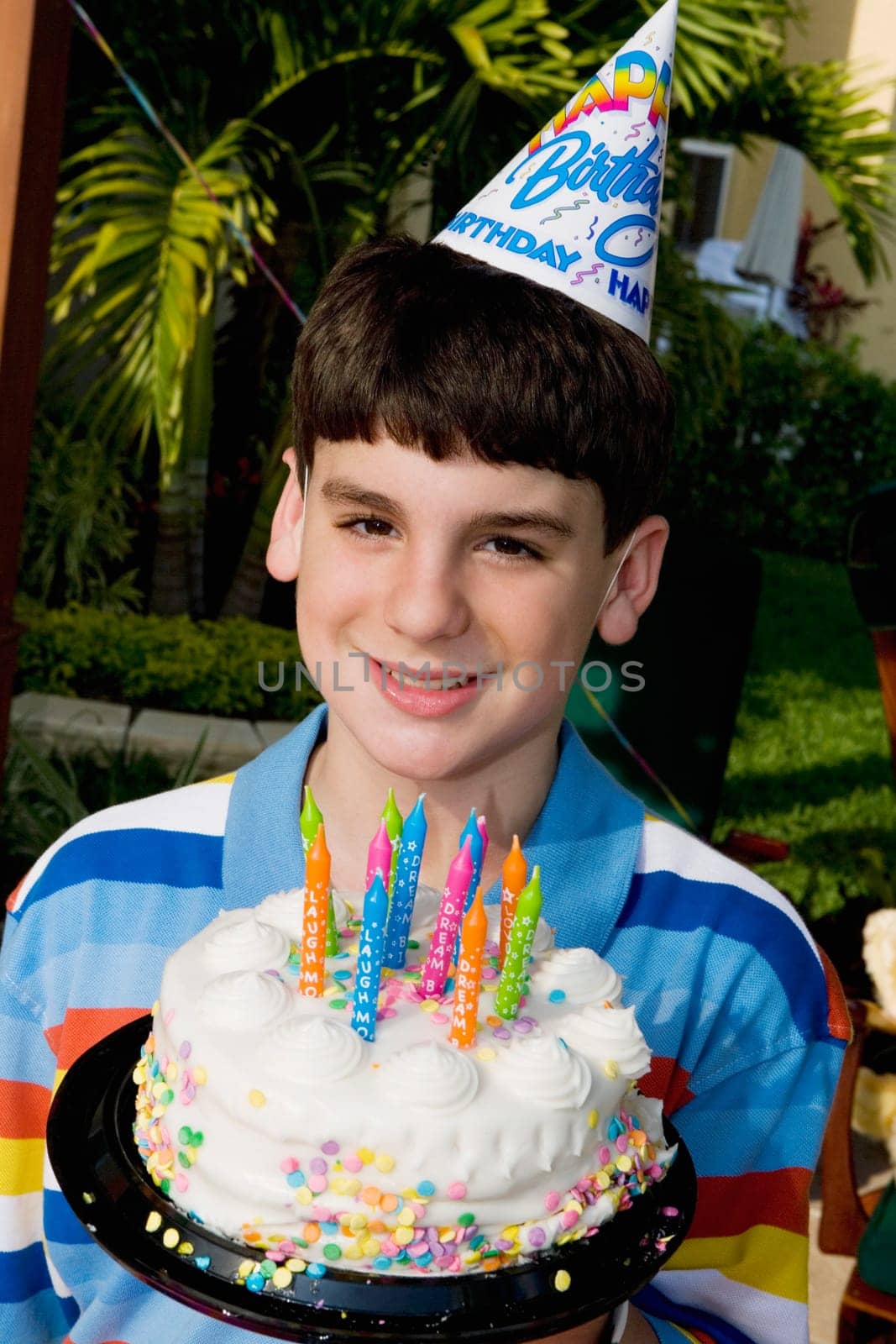 Portrait of a boy holding a birthday cake and smiling