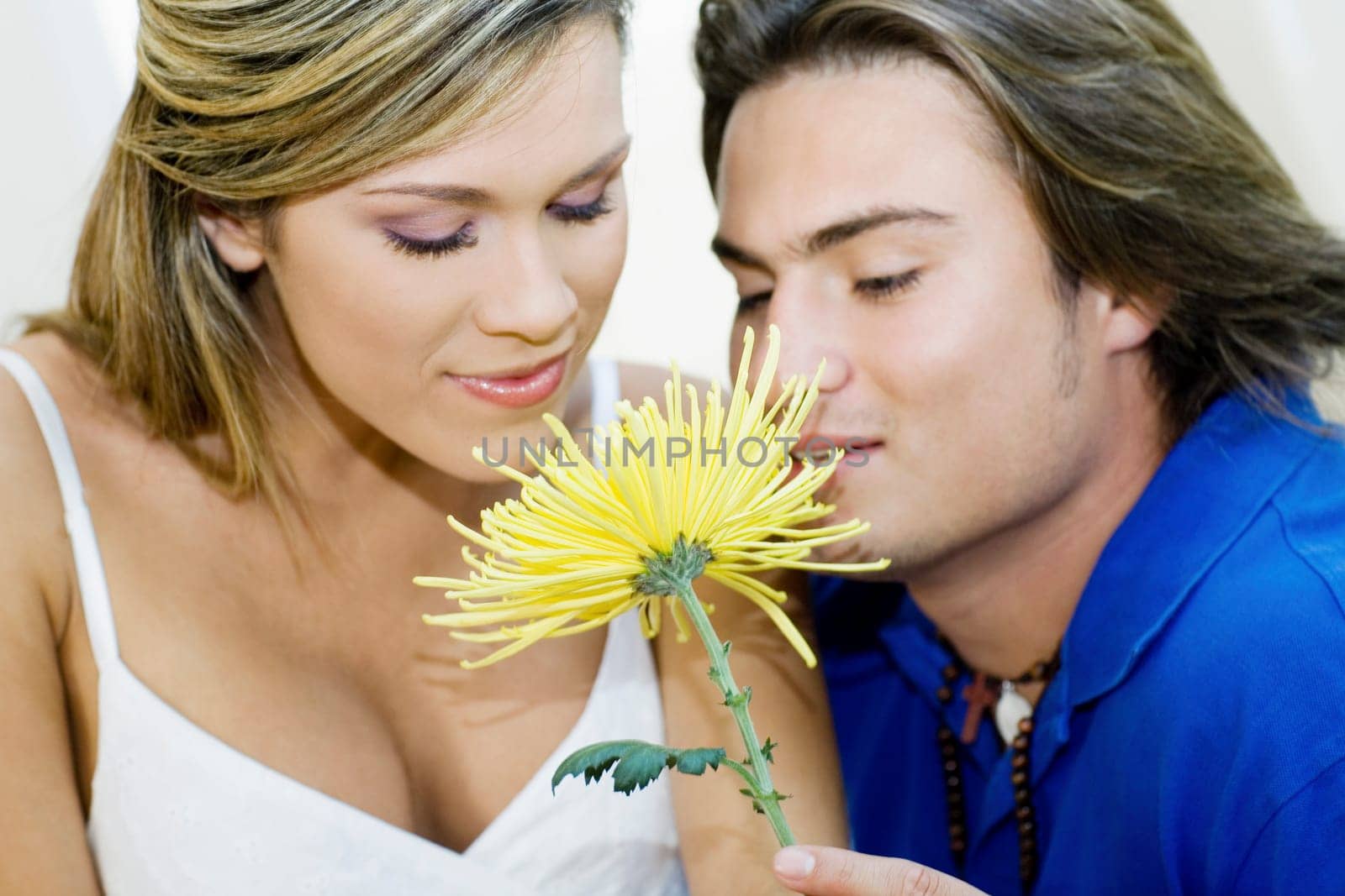 Close-up of a young couple smelling a flower