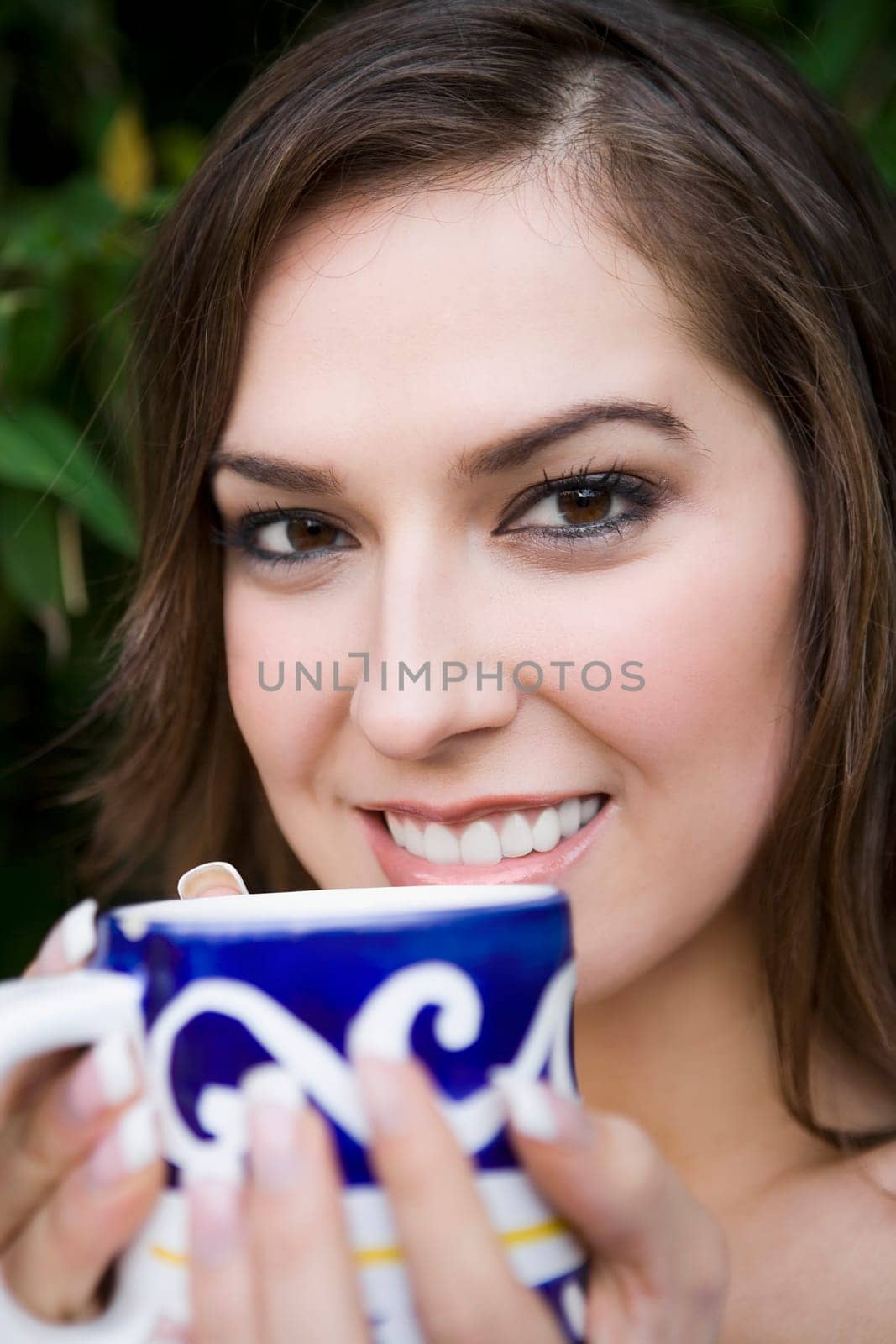Portrait of a young woman holding a tea cup and smiling