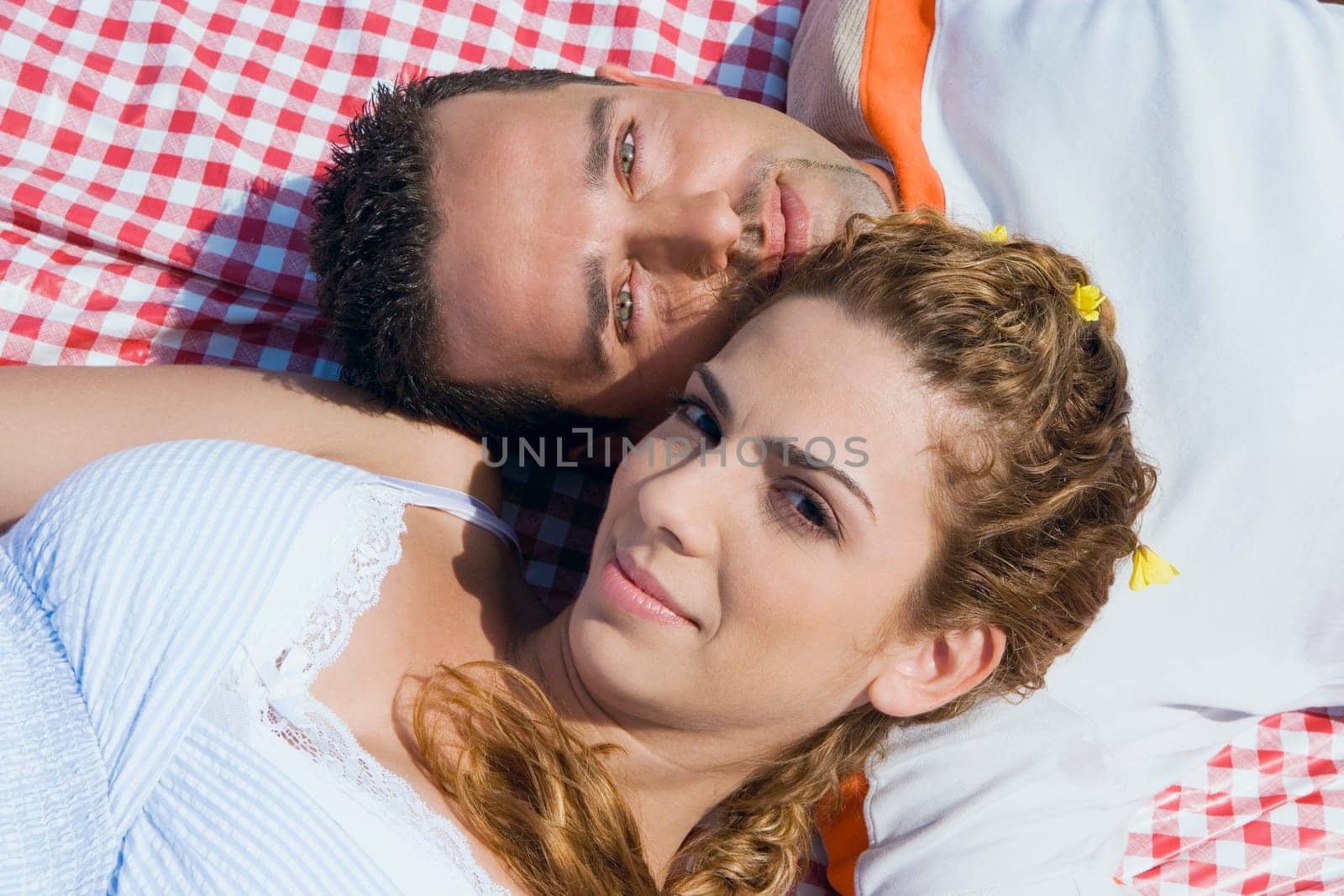 High angle view of a mid adult couple lying on a picnic blanket