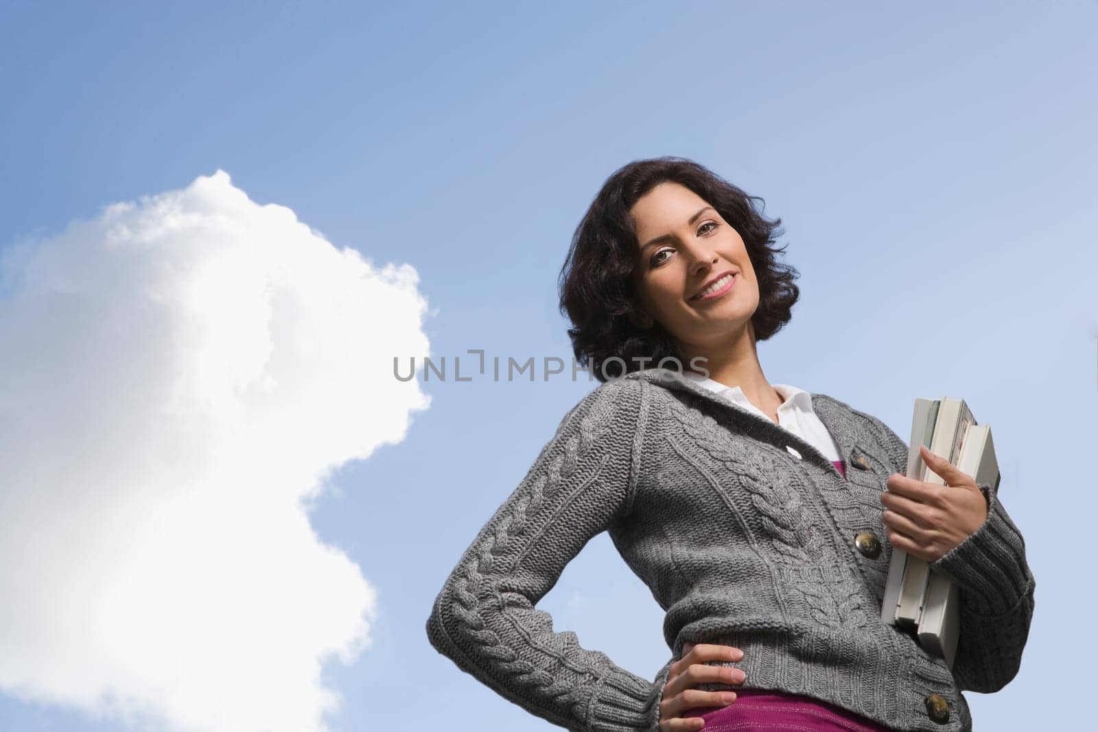 Low angle view of a young woman holding textbooks