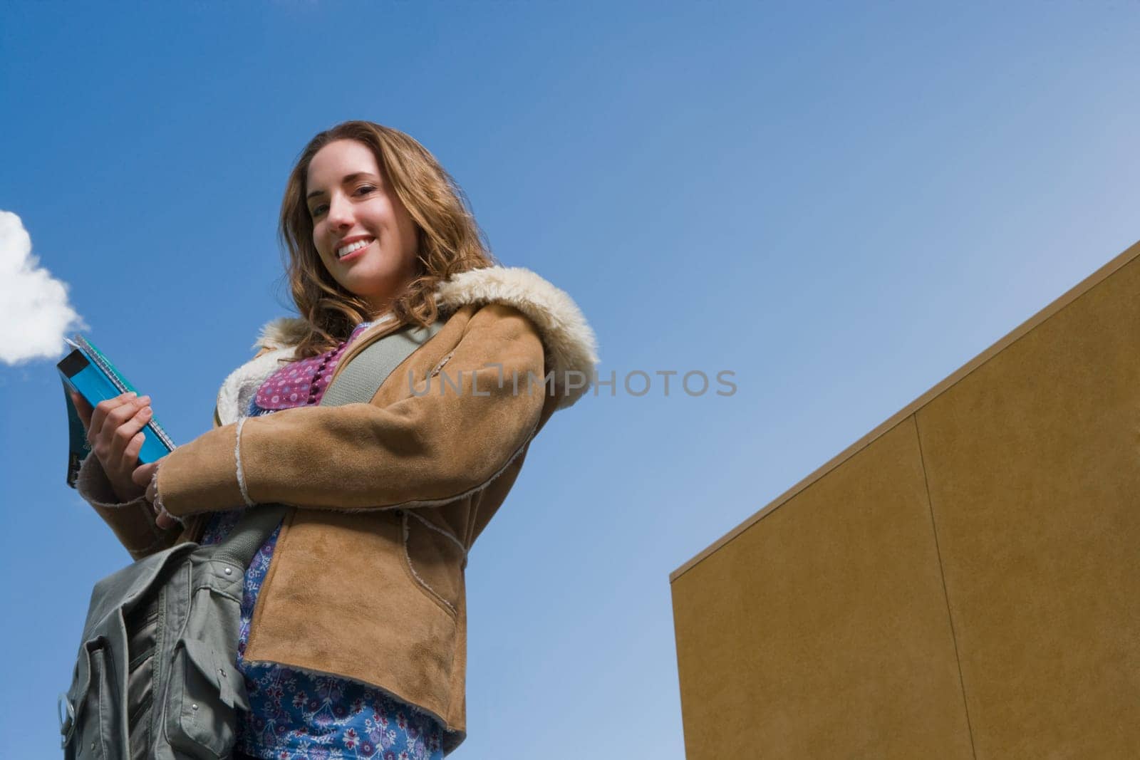 Low angle view of a young woman holding textbooks