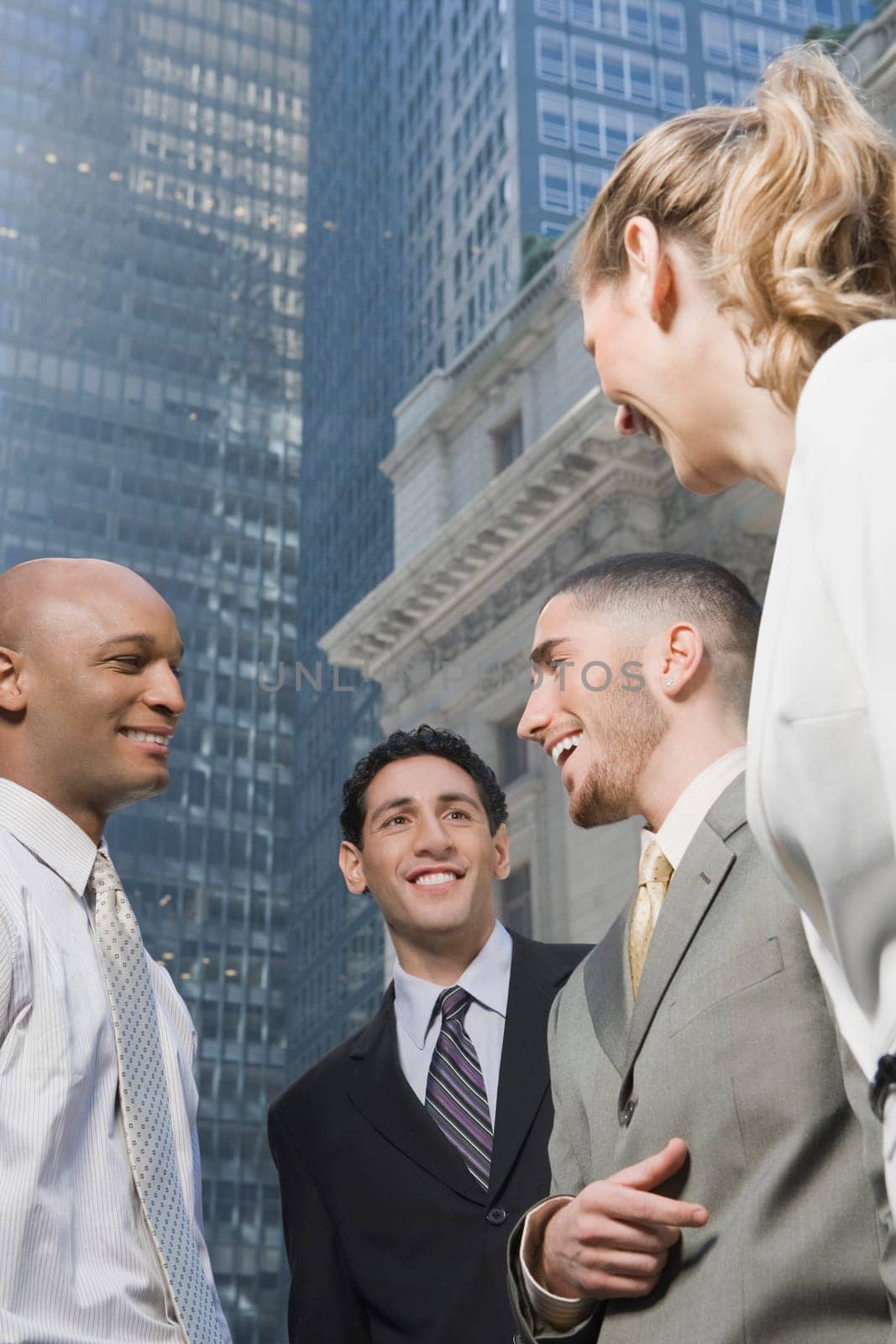 Side profile of a businesswoman standing with three businessmen