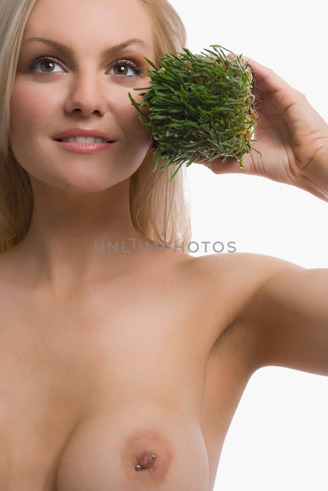 Close_up of a young woman holding wheatgrass and smiling