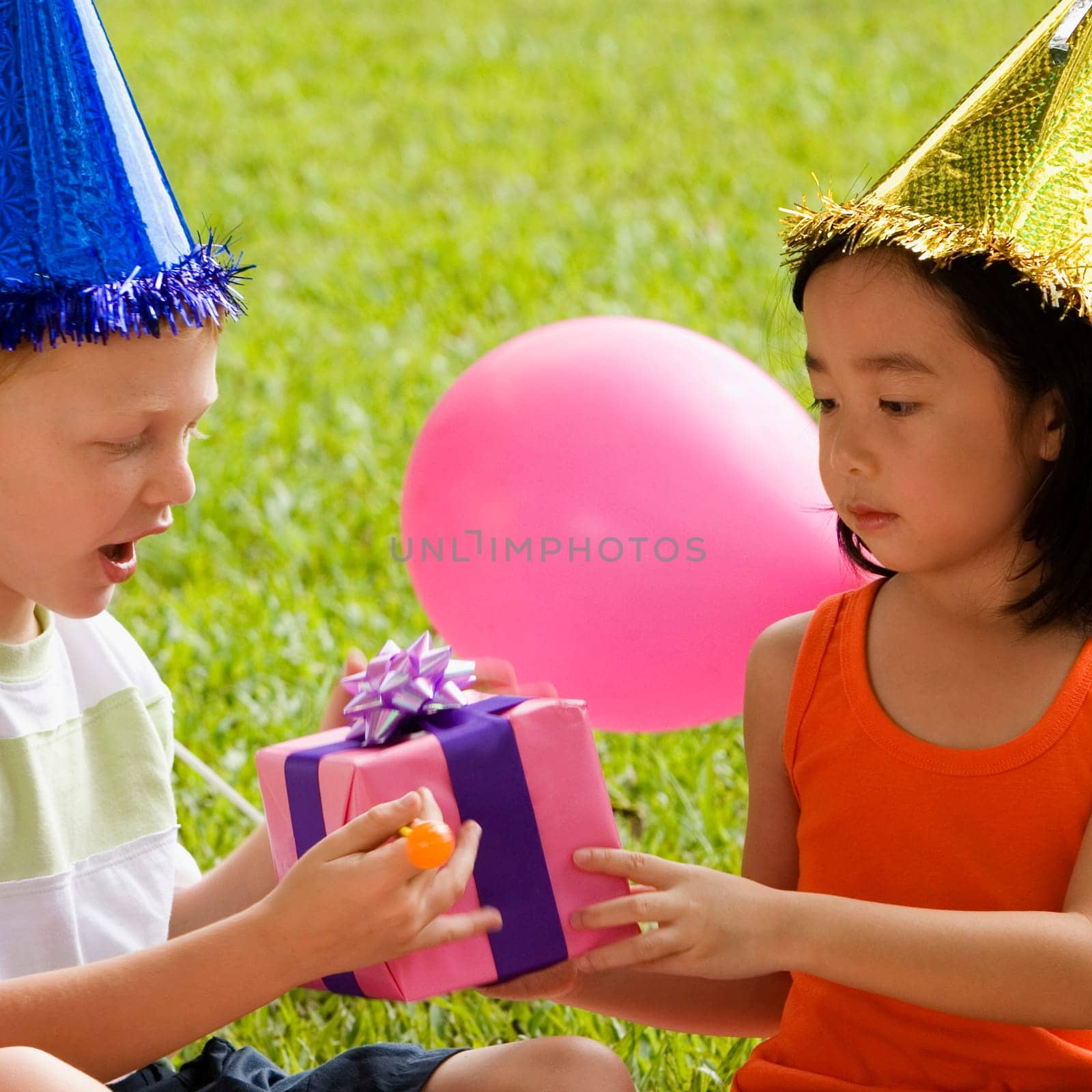 Close_up of a boy giving a birthday present to a girl