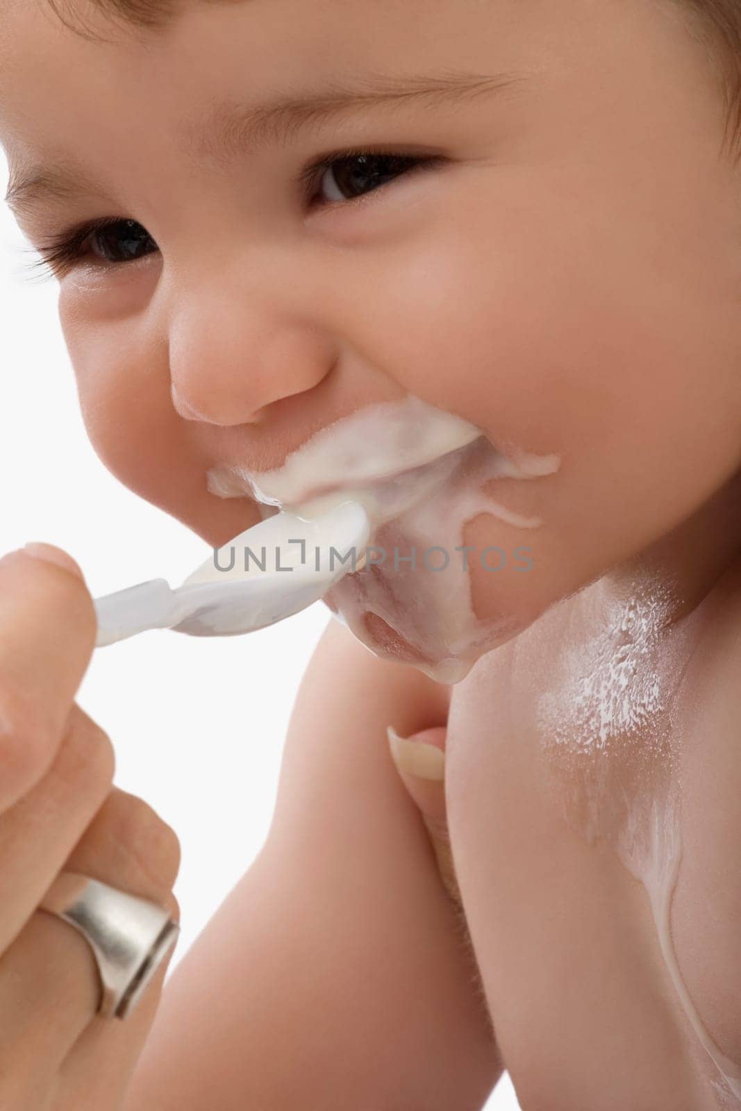 Close_up of a personŽs hand feeding baby food to a baby boy