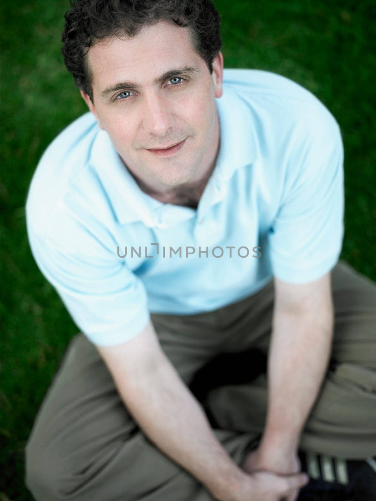 Portrait of a mid adult man sitting in a park and smiling